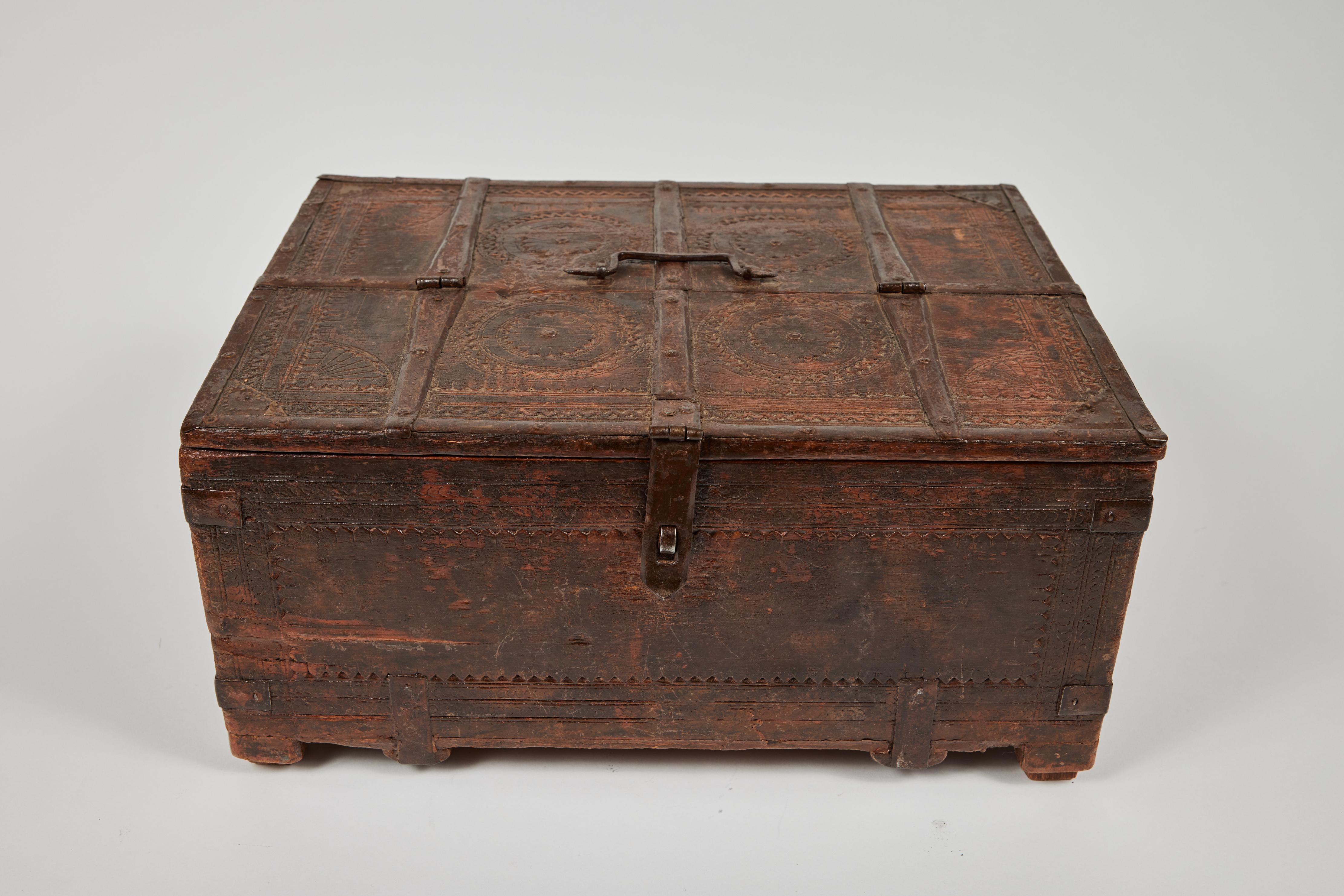 Antique large footed wood keepsake box with hand tooled decoration, hinged lid and metal handle and fittings.