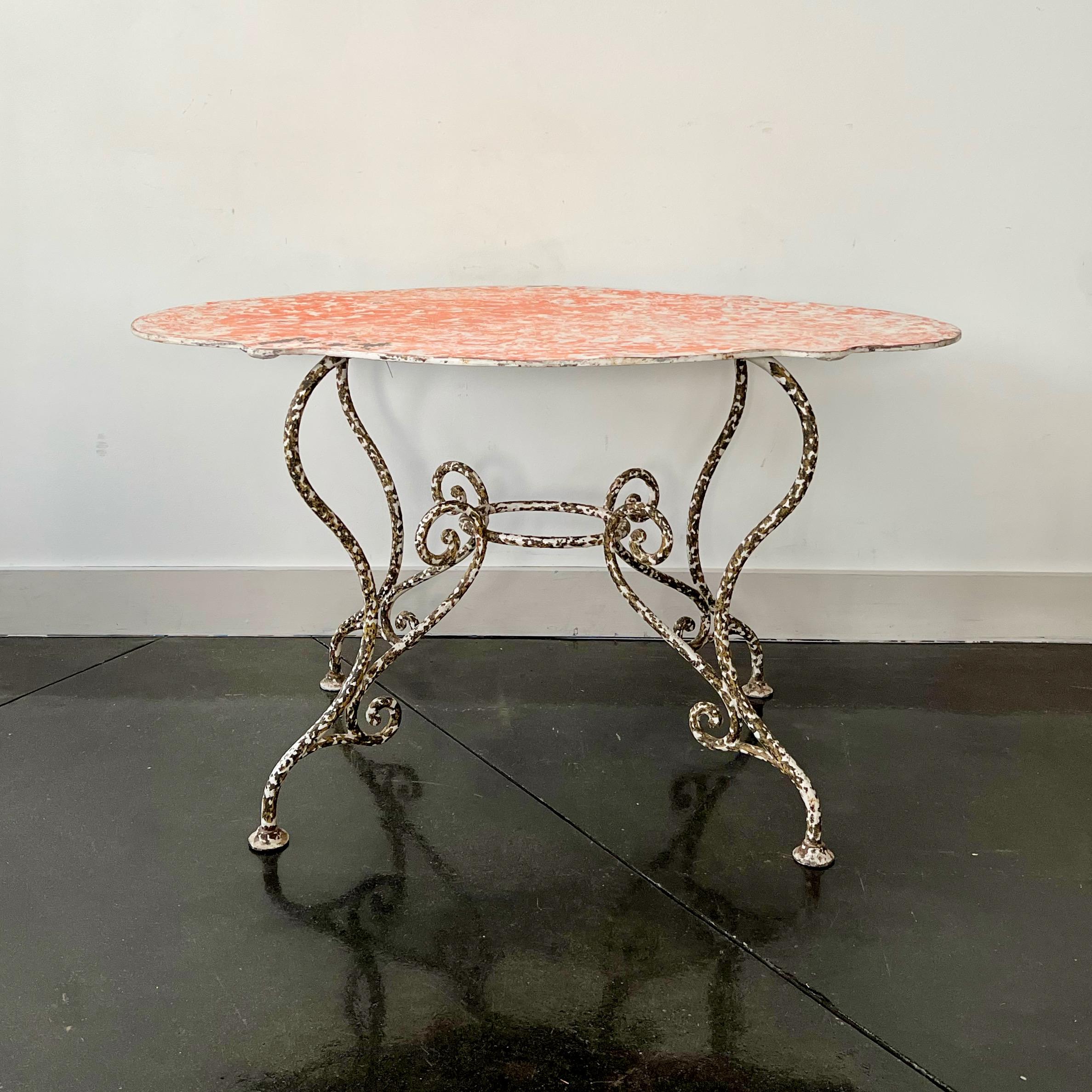 Exceptionally large late 19th century French Arras style oval shaped iron table with beautiful scrolling wrought iron base in chipped paint - structurally in excellent condition.