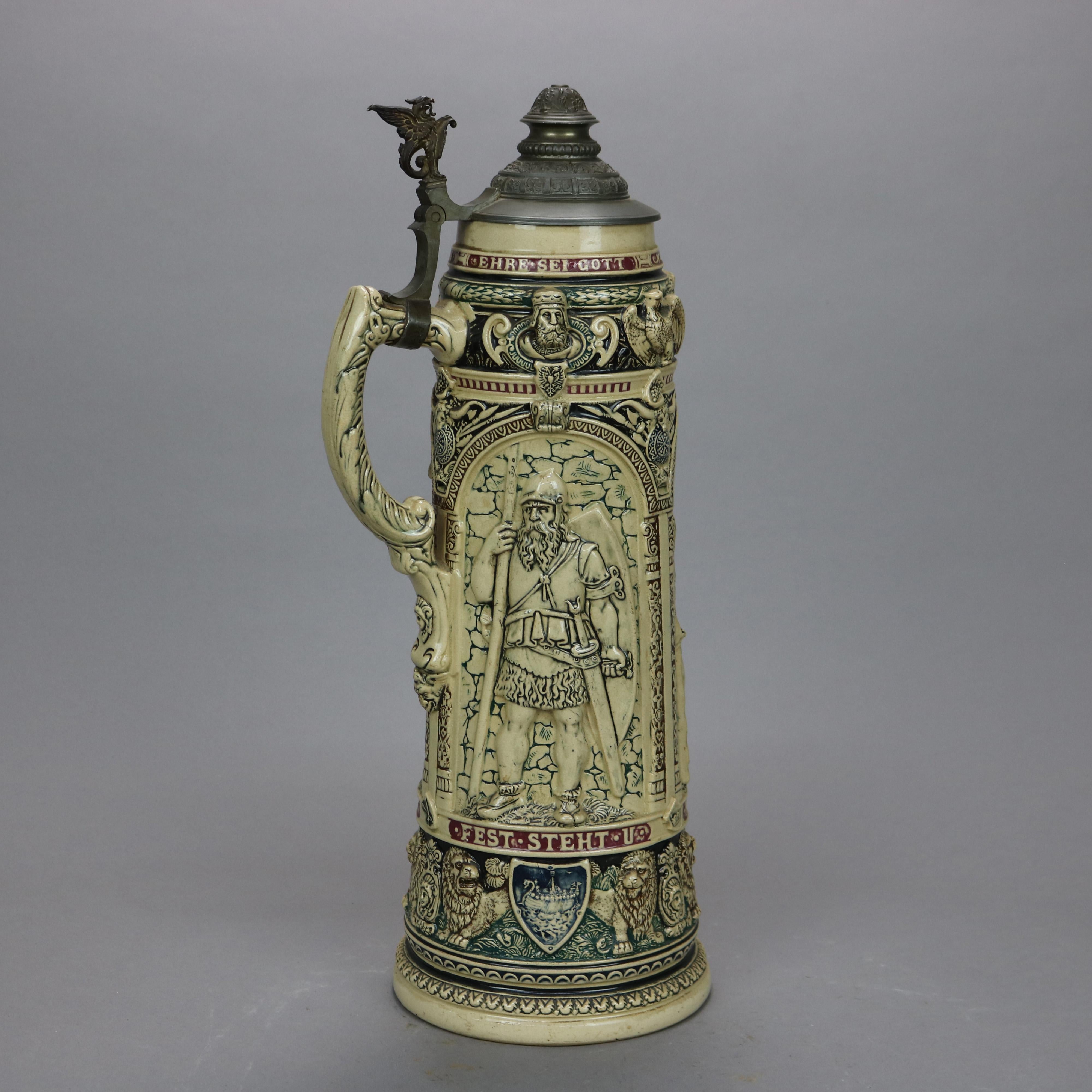 An antique and large German beer stein offers stoneware construction with reserves having figures and verbiage in relief, scroll form handle and hinged pewter lid having figural griffin handle, c1900

Measures - 19.25'' H x 8'' W x 6.5'' D.