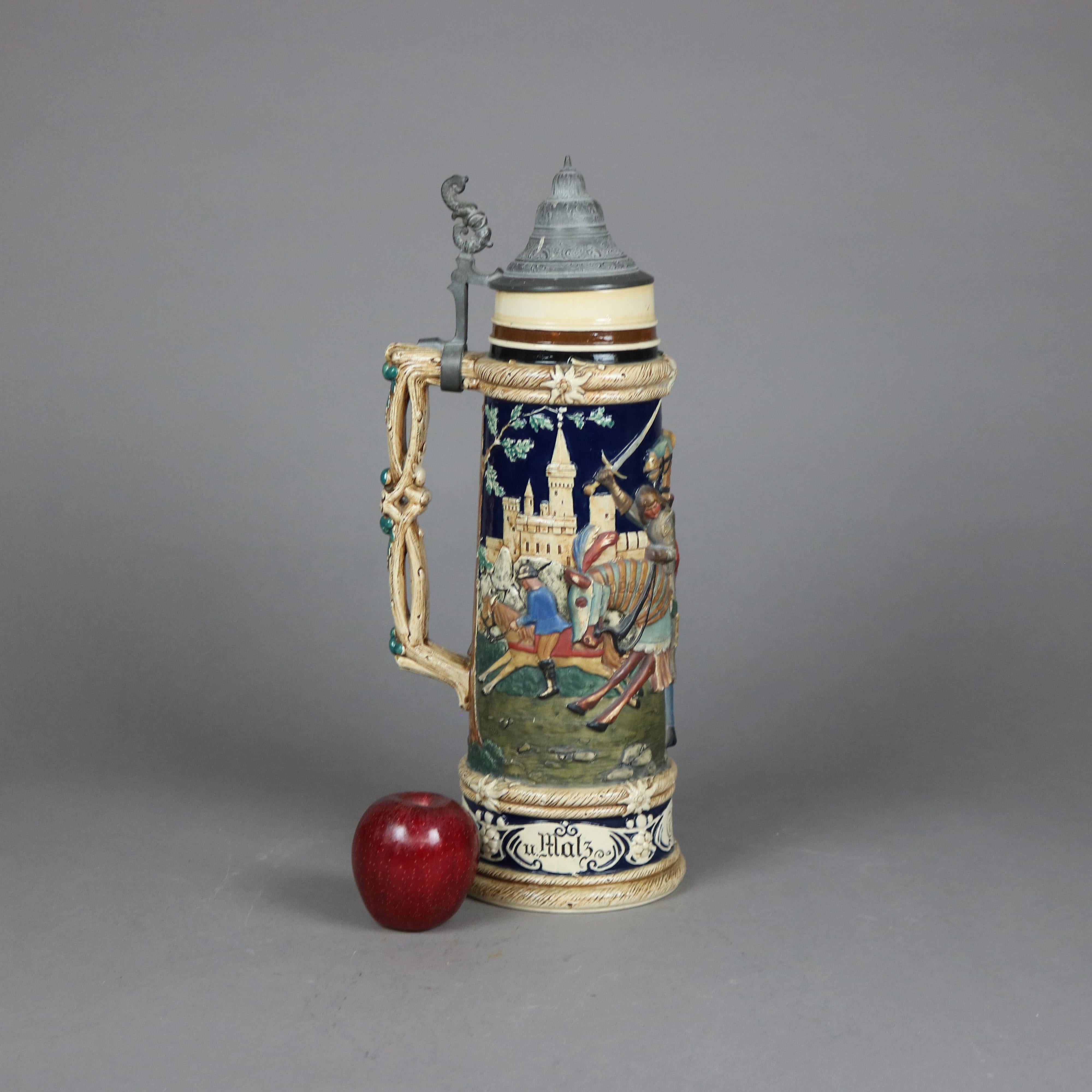 An antique and large German beer stein offers stoneware construction with knight and castle scene in relief, branch form handle and hinged pewter lid having figural dolphin handle, Hopfen (hops) and stamped as photographed, c1900

Measures - 18'' H