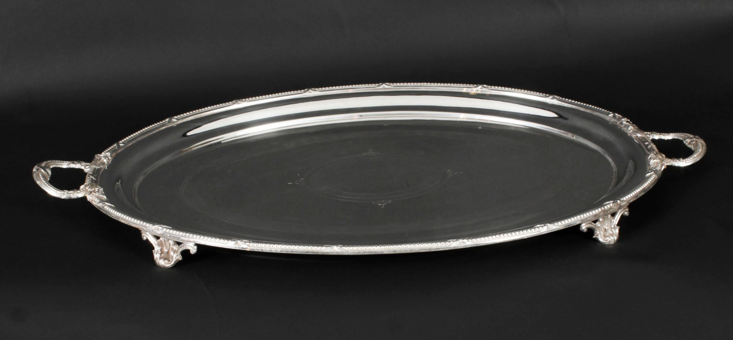 This is a momumental beautiful antique German oval silver-plated twin handled tray by I.H.Peters & Co, Hamburg,  dating from the mid 19th Cntury.

The tray is of oval form, with a bow-tied beaded border, and two foliate capped handles. It is