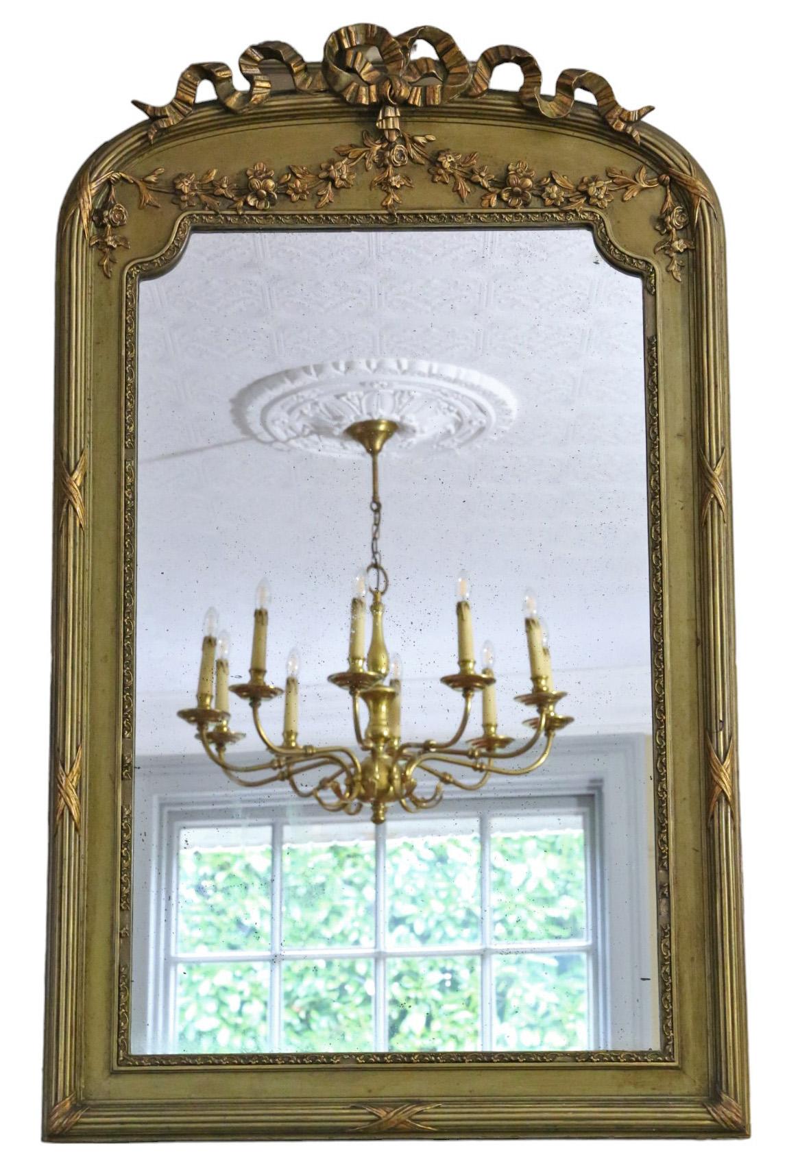Antique large gilt overmantle wall mirror, crafted around 1900, boasting fine quality with ribbon and floral decoration.

This mirror captivates with its simple yet striking design, infusing character into any suitable space. The frame is sturdy,