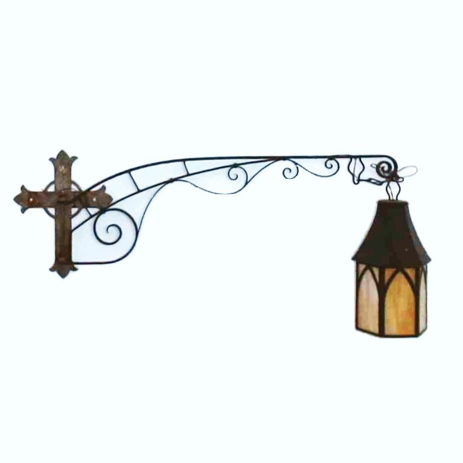 A large antique Gothic Arts and Crafts church light offers hammered crucifix wall plate with swinging scroll form wrought iron arm terminating in lantern style light housing slag glass panels, 19th century

Measures- Overall 66.5''H x 12''W x 29''D;