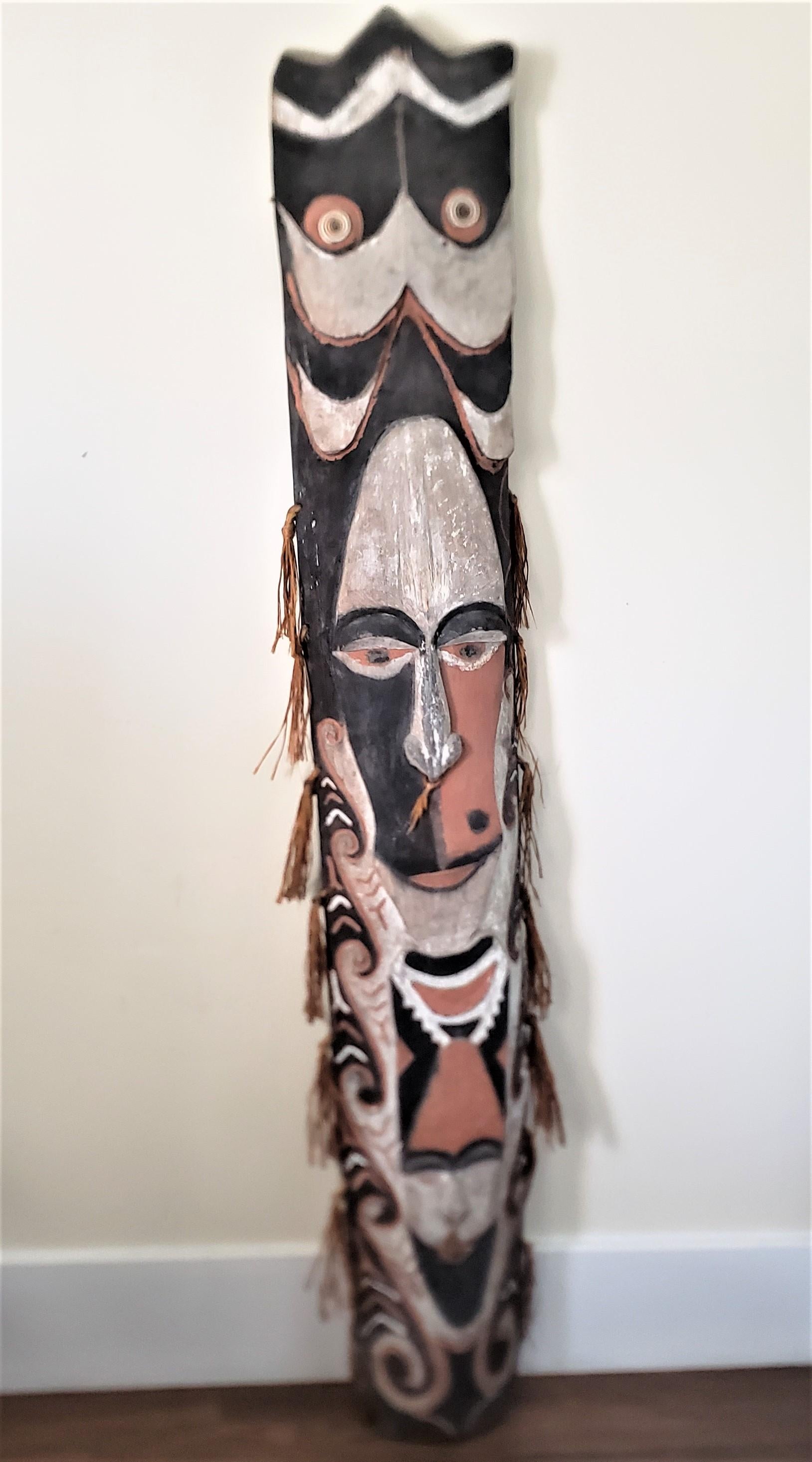 This large antique tribal mask or sculpture is unsigned and undocumented, but presumed to have originated from Southeast Asia and done in a folk art style. The sculpture os composed of a fragment from a softwood tree and has been hand-carved with a