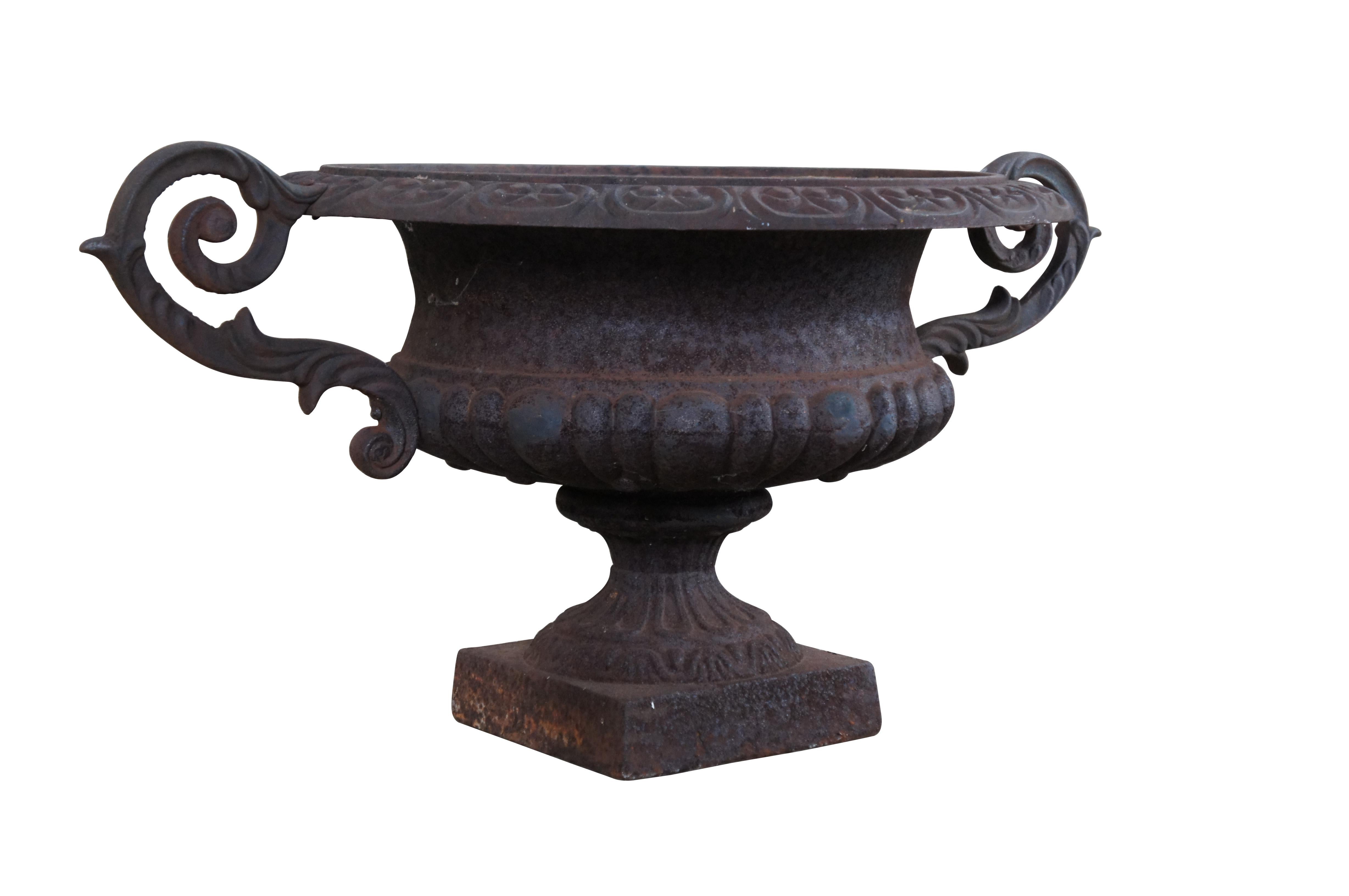Antique cast iron garden urn or planter with ornate scrolled handles and square pedestal base.  

Dimensions:
35