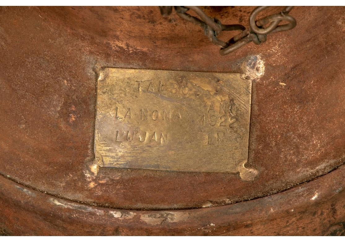 A large and very decorative twin handled jug with a lid attached with a chain. A brass plaque on the side is labeled: Tambo La Nona Ano 1922 Lu Jan LM. Desirable signs of age including some areas of green patination to the copper. The lid cannot now