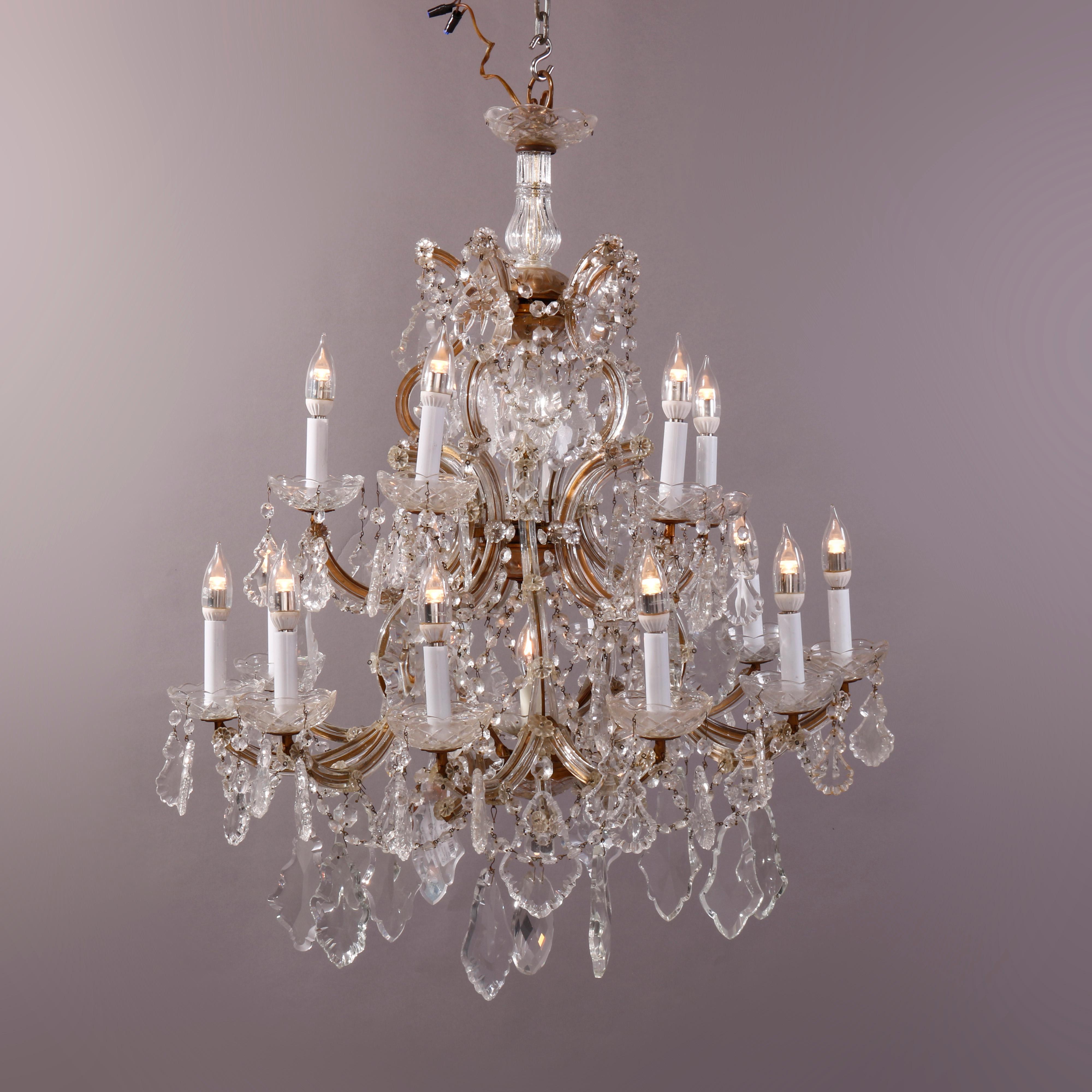 An oversized antique Italian style chandelier offers brass frame with tiered scroll form arms terminating in sixteen candle lights and having strung and drop cut crystals throughout, c1930

Measures - fixture 34''H x 27.5''W x 34''D.

Catalogue