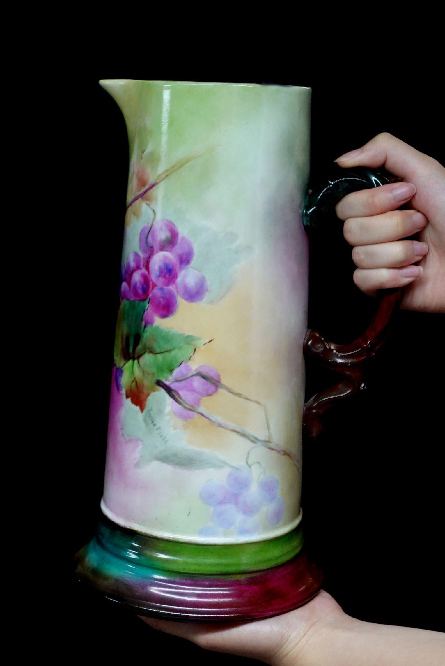Une merveilleuse grande antiquité J.P. Cette chope en porcelaine décorée de fleurs offre un bord en forme de courbe absolument 100% peint à la main de raisins en rouge, brun-rouge, violet, et de riches feuilles vertes, un arrangement délicat de la