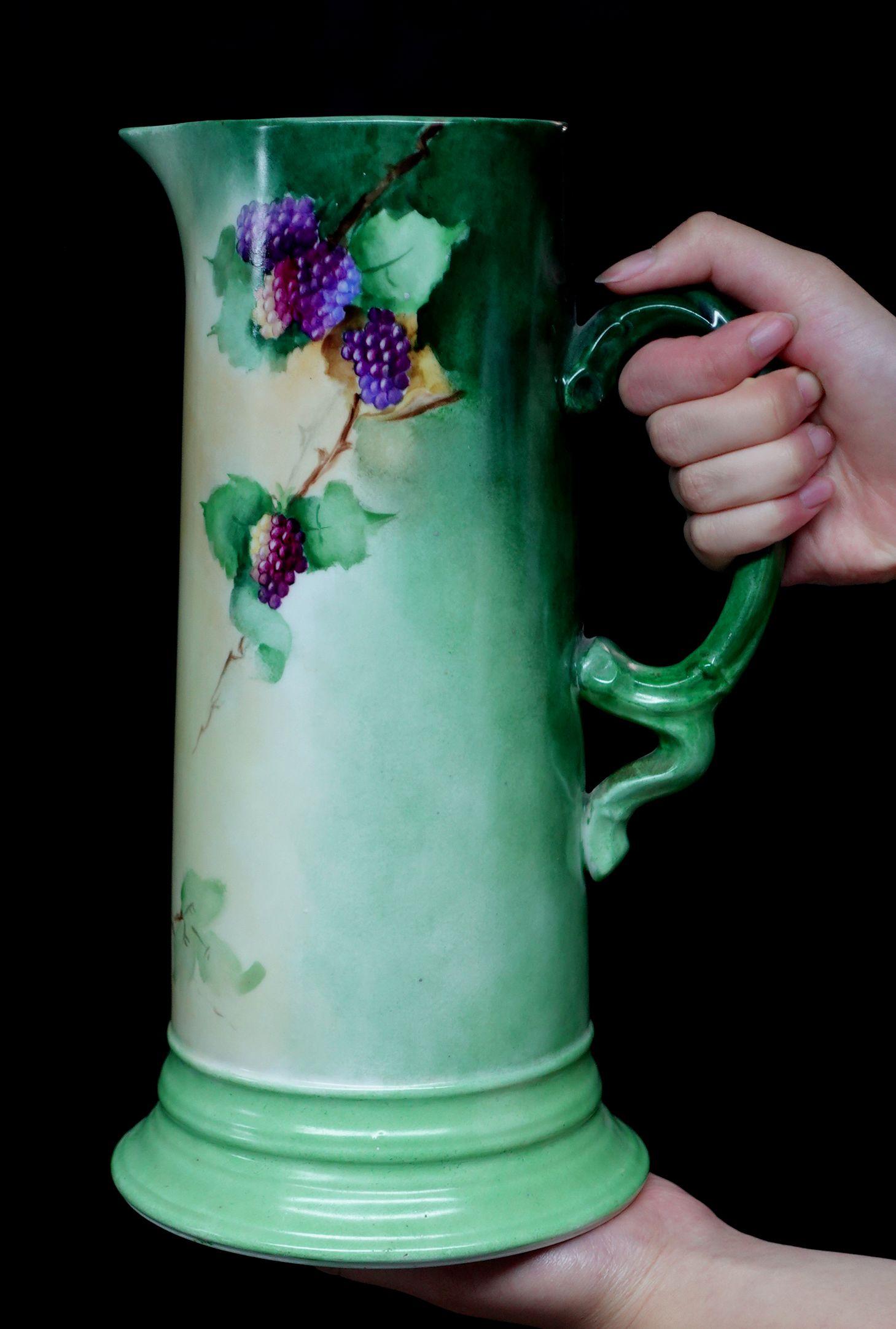 Une merveilleuse grande antiquité J.P. Cette chope en porcelaine décorée de fleurs offre un bord en forme de courbe absolument 100% peint à la main de raisins en rouge, brun-rouge, violet, et de riches feuilles vertes, un arrangement délicat de la
