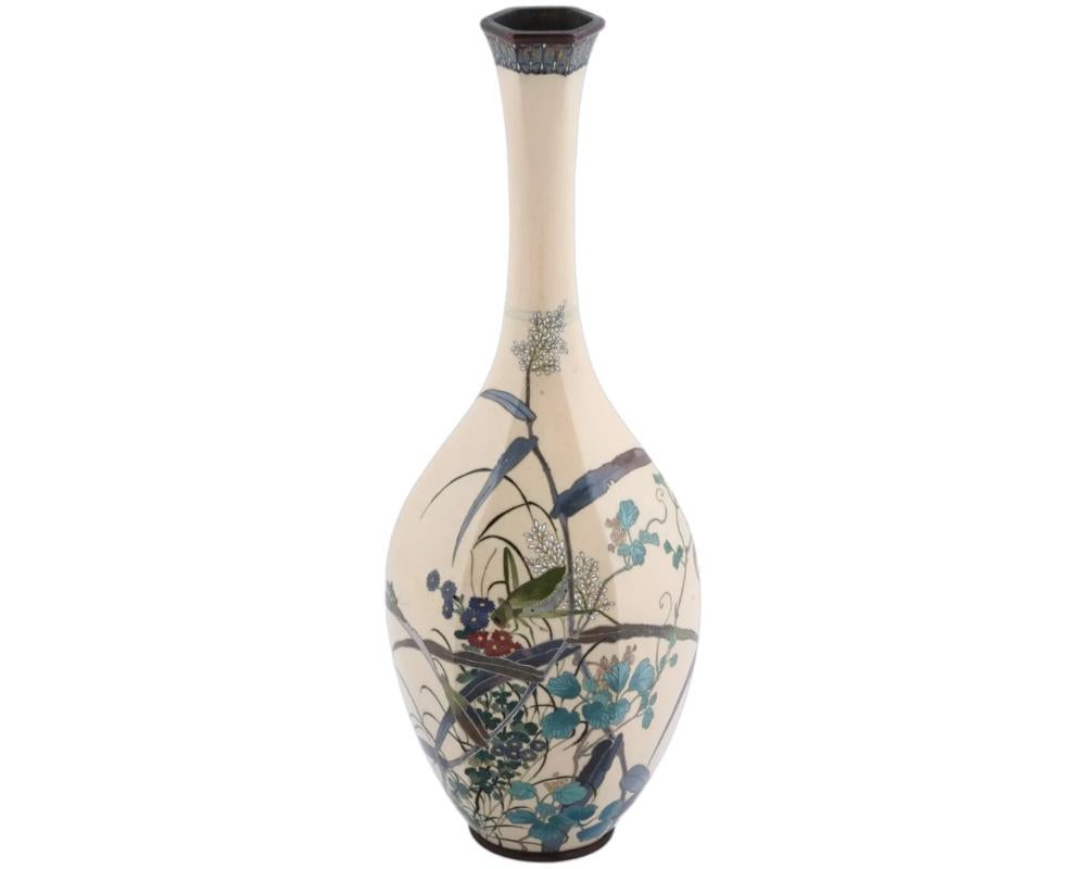 A good quality antique Japanese Meiji era, circa 1895, silver plated brass and cloisonne enamel vase of a slended bulbous form, finely decorated with a floral arrangement and a grasshopper sitting on a branch on an unusual cafe au lait colour ground