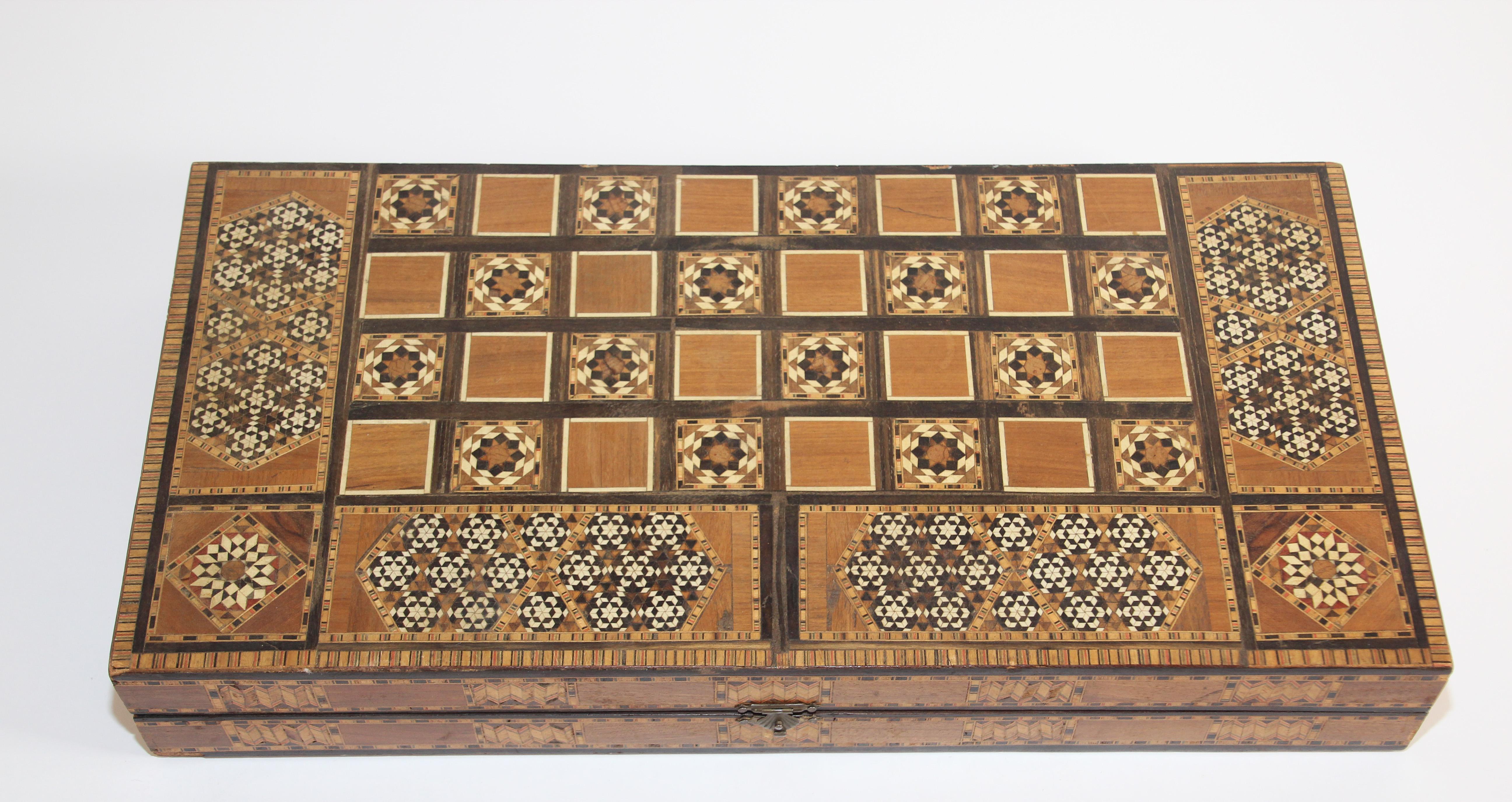 Large antique Middle Eastern Syrian inlaid with mother of pearl marquetry mosaic backgammon game.
Great inlaid micro mosaic hinged marquetry game box features a chess and checker board on the exterior and backgammon board on the interior with all