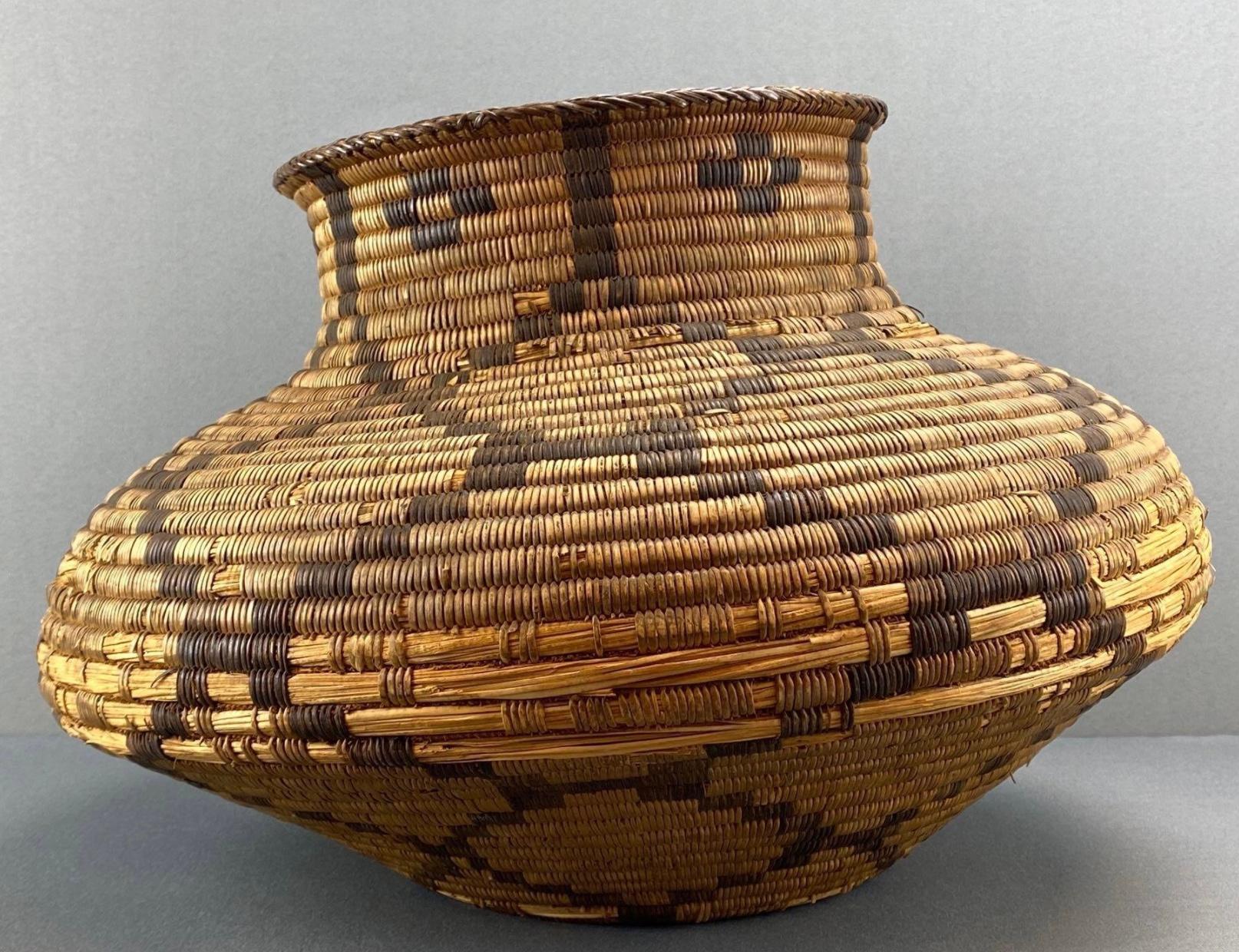 Cette antique Olla des Indiens d'Amérique du Nord est tissée en saule et en griffe du diable, avec une décoration géométrique, en damier et picturale en bandes. Rare, ce grand panier s'expose bien et fera un ajout étonnant à la collection de