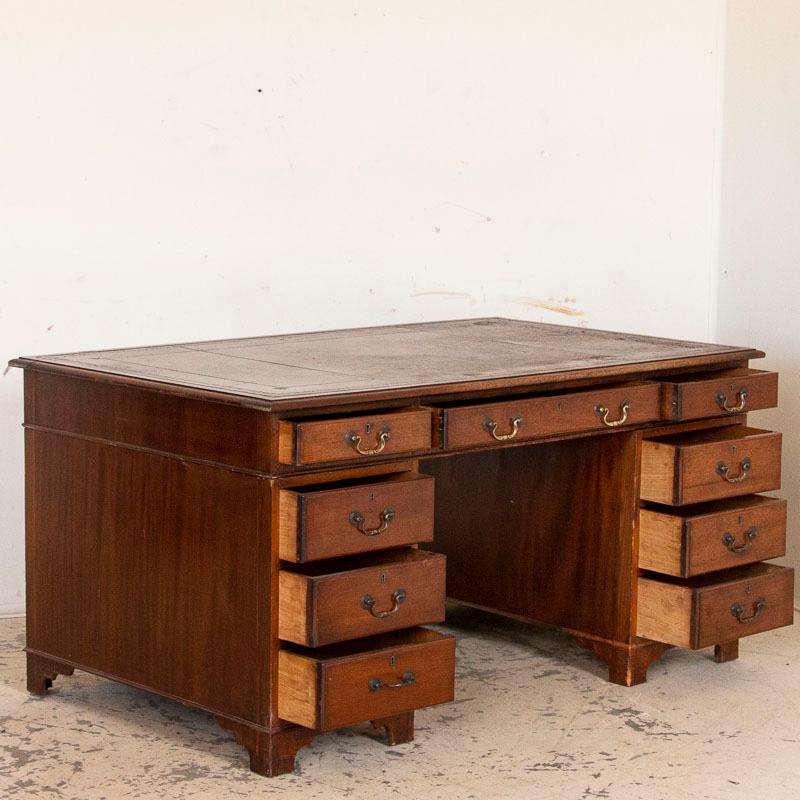 This large oak desk offers tremendous storage and functionality due to the 9 drawers. To the left and right of the front open seating area are 4 vertical drawers and over the top center is one narrow drawer. The back side is open for seating with no