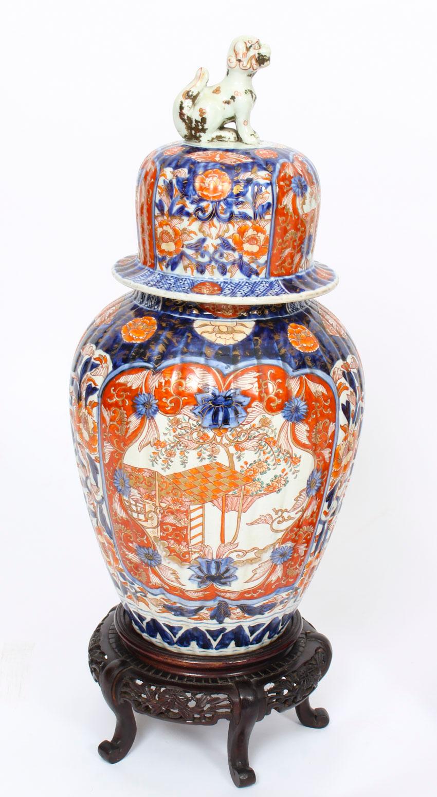 This is a large pair of Japanese Imari jars with covers on stands, circa 1870 in date.

The vases are of elegant bulbous shape with vertically inverted reeding and have domed covers which are surmounted by attractive foo dogs.

The pair of vases