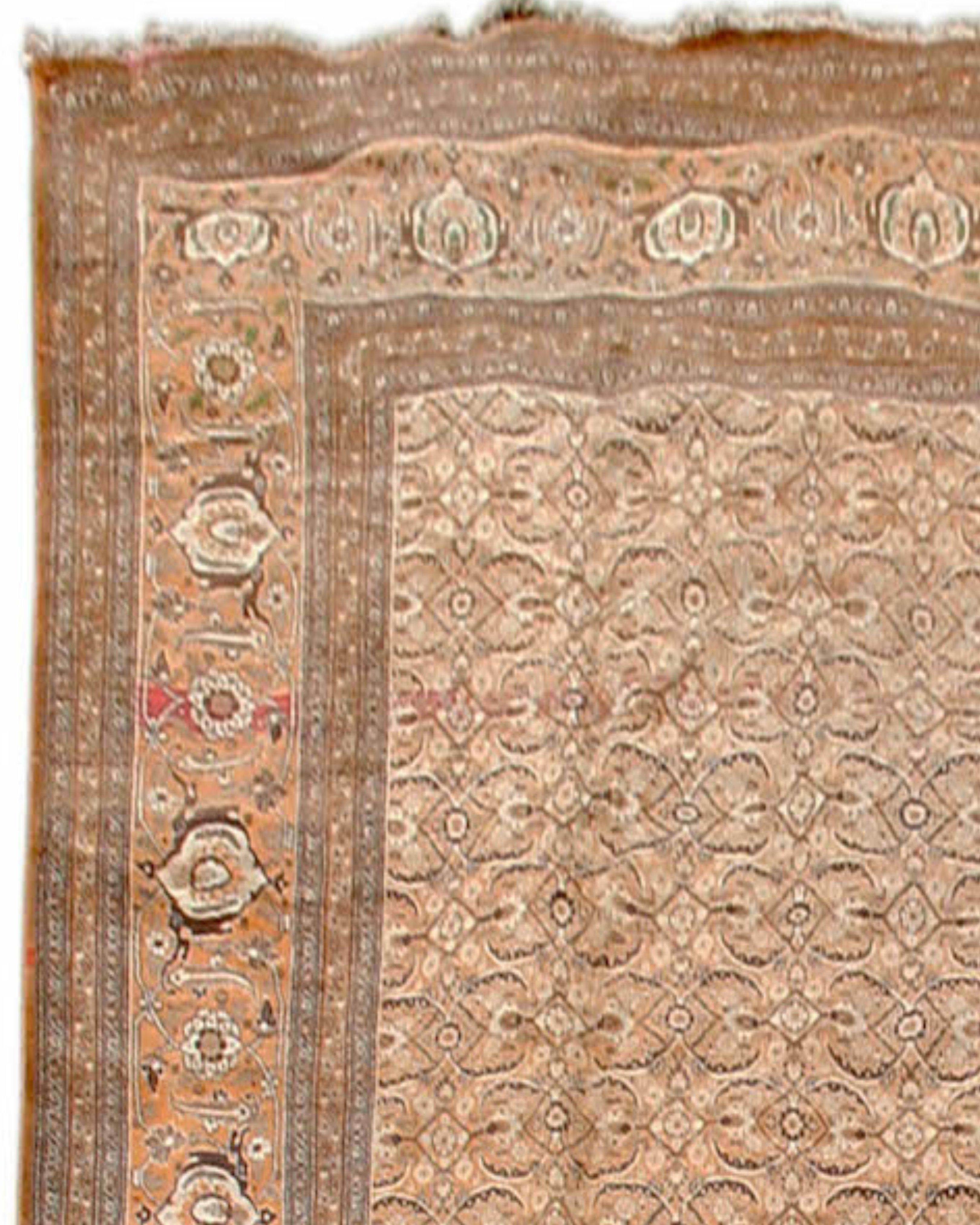 Antique Large Persian Tabriz Rug, 19th Century

This magnificent over-sized Tabriz carpet paints an overall field using the so-called Herati pattern. Delicate feather-shaped palm fronds extend horizontally in a lattice grid with rosette centers. The