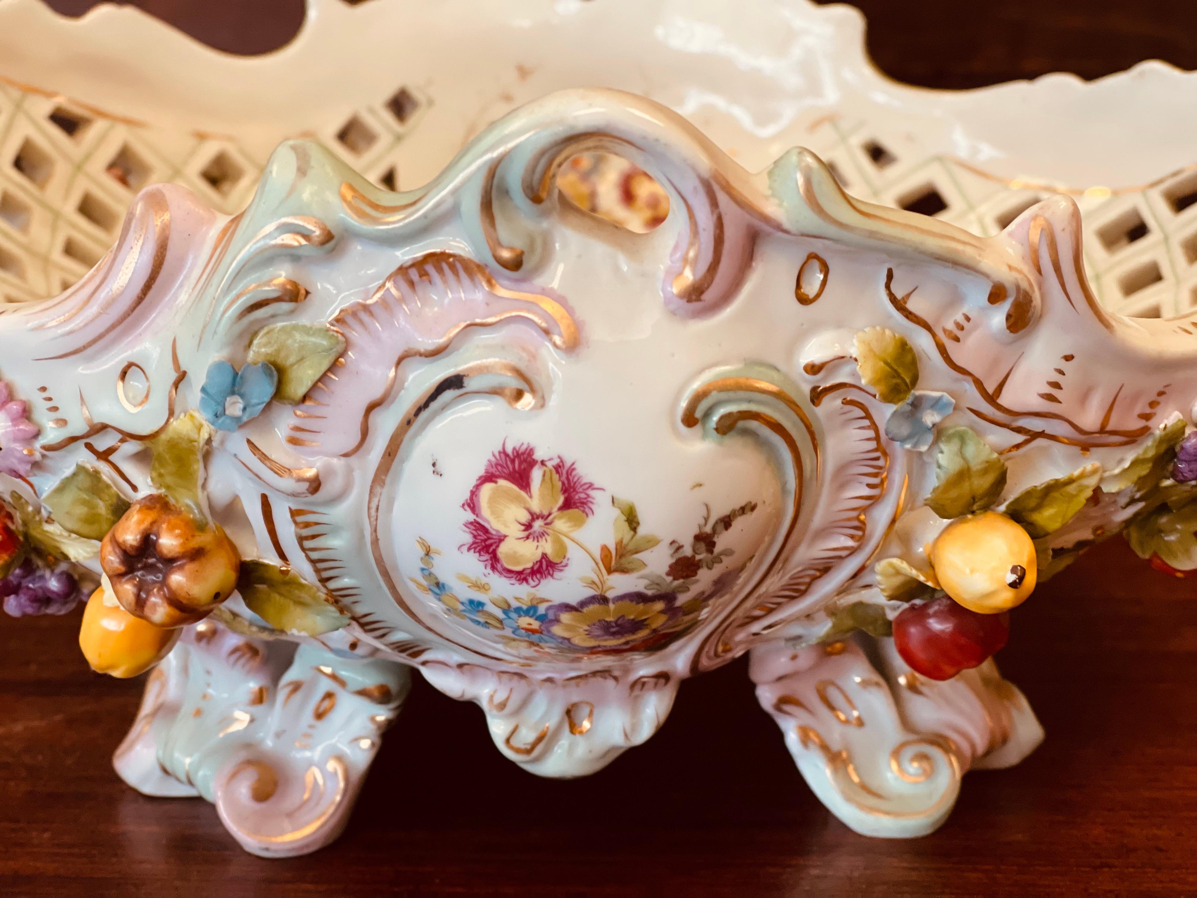 This exquisite Meissen antique centerpiece bowl is a true masterpiece of German craftsmanship. The bowl features raised flowers and fruit and is beautifully hand-painted with a stunning backstamp. It is a large and magnificent piece, perfect for any