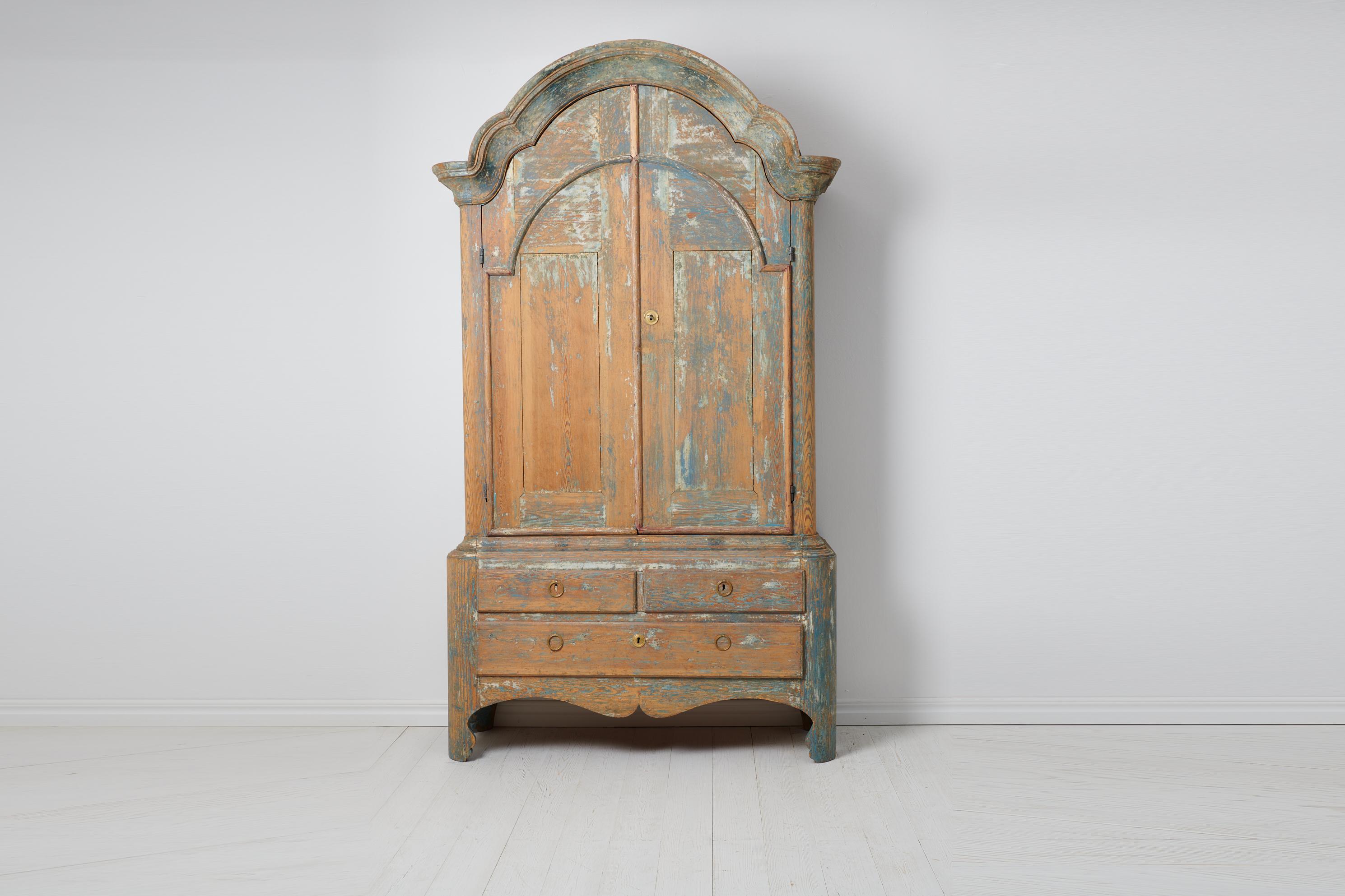 Rare large rococo cabinet from northern Sweden made during the last decades of the 18th century, around 1780 to 1790. The cabinet is made in Swedish pine in two parts with traces of the original blue paint. The paint has significant distress. The