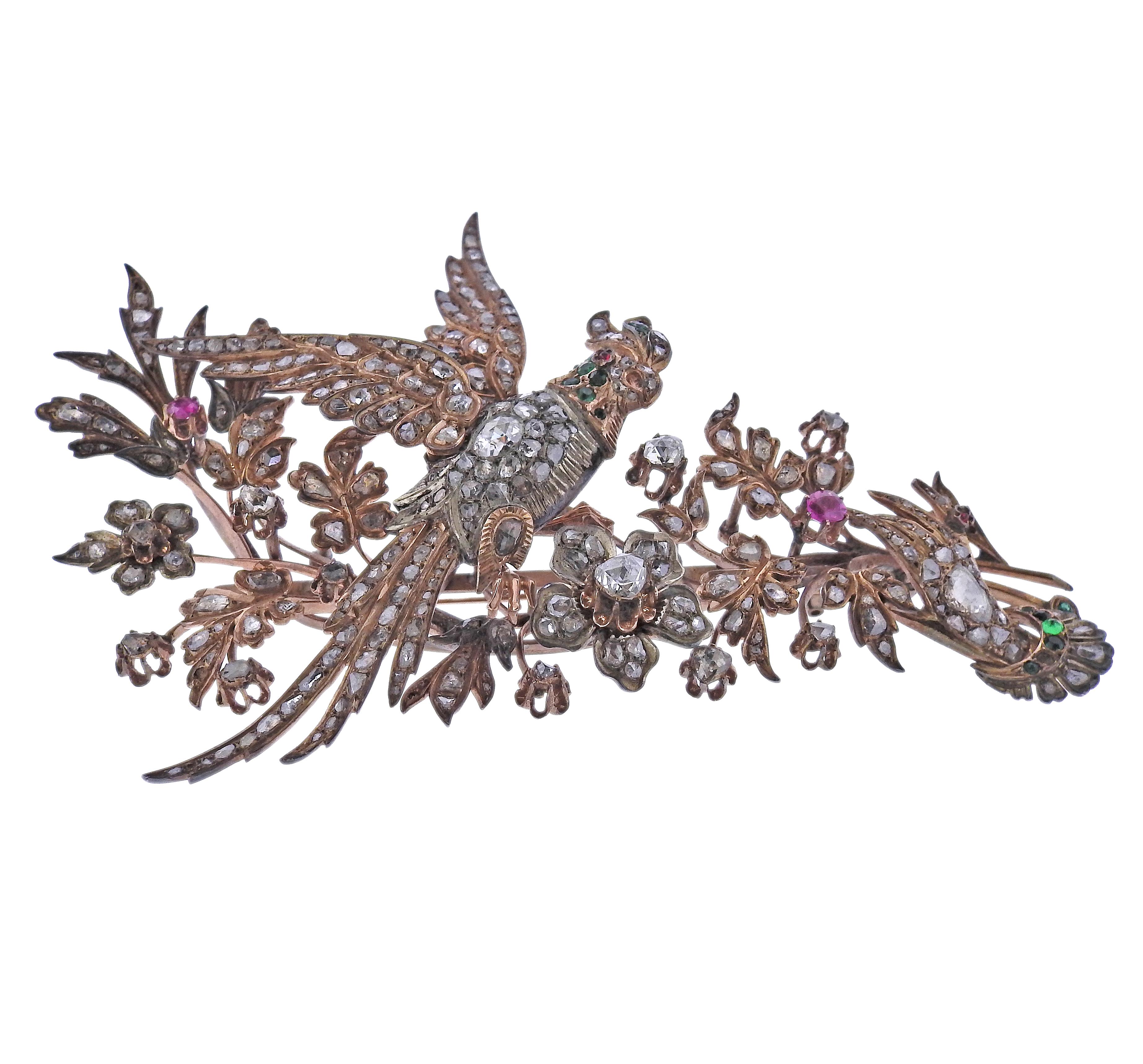 Große antike Goldbrosche, die einen Vogel mit Blumen darstellt. Besetzt mit Diamanten im Rosenschliff, Smaragden und Rubinen. Mehrere Steine sind abgesplittert und/oder fehlen. Brosche misst 4,5