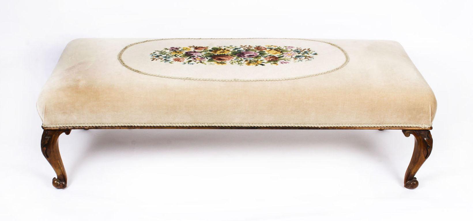 This is a large antique 19th century Mid-Victorian mahogany stool / ottoman with stuff over seat upholstered in a sumptuous beige velvet with an inset oval floral tapestry panel, circa 1860 in date. 

Raised on finely carved cabriole