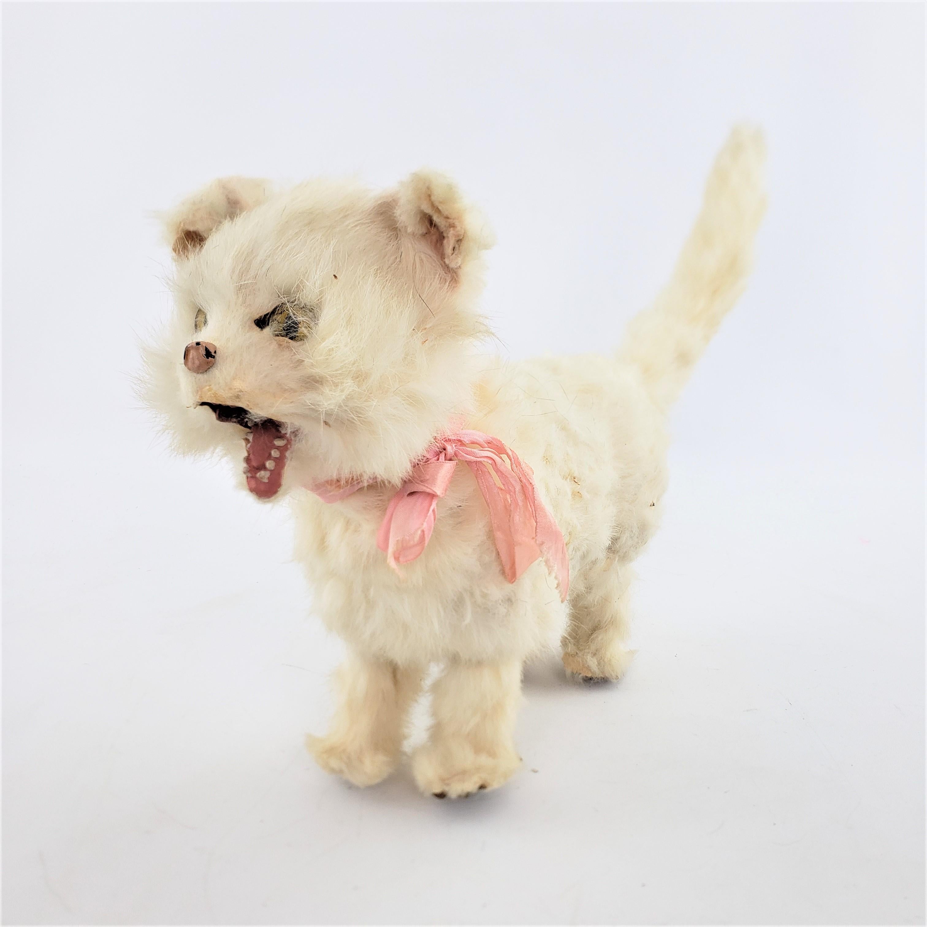This antique mechanical toy is unsigned, but presumed to have been made in Europe, possibly England or Austria in approximately 1880 and done in the period Victorian style. The toy is a very large mechanically articulated white cat, which would have