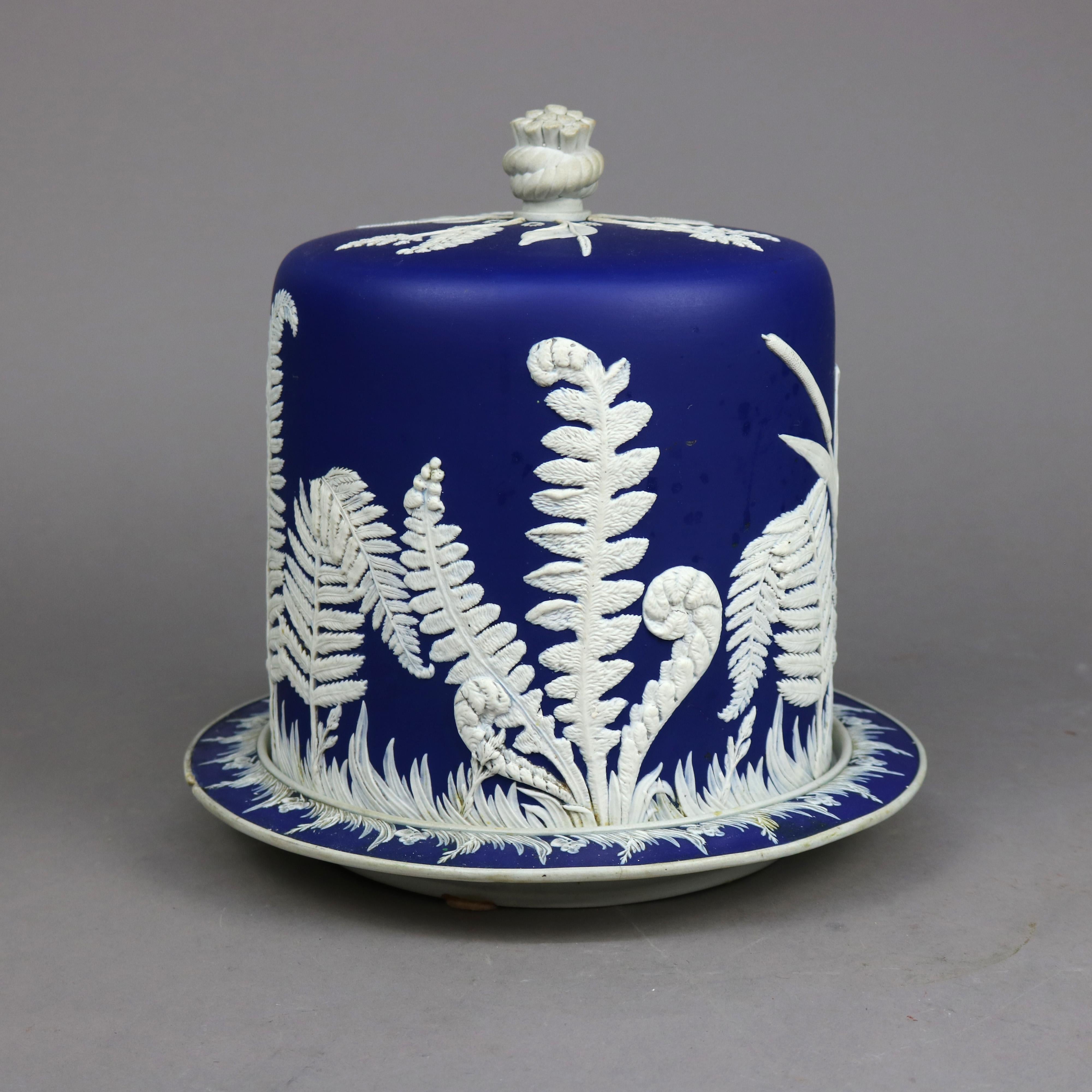 An antique and large English jasperware cheese keeper in the attributed to Wedgwood offers bisque porcelain construction with white fern cameo in relief on a cobalt blue ground, 19th century

Measures - 11.75''H x 11.5''W x 11.5''D.