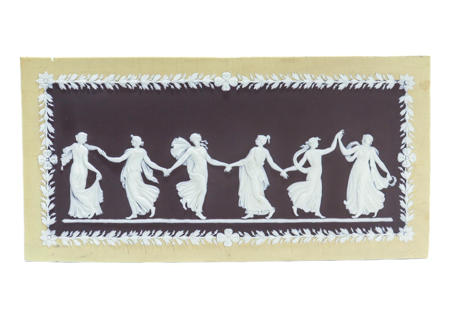 Une belle plaque ancienne en jasperware de Wedgwood.

Dans le modèle Dancing Hours.

En trois couleurs dont une bordure jaune, une décoration en camée appliquée blanche et un centre noir.

Marqué au revers d'une marque WEDGWOOD (uniquement).

Datant