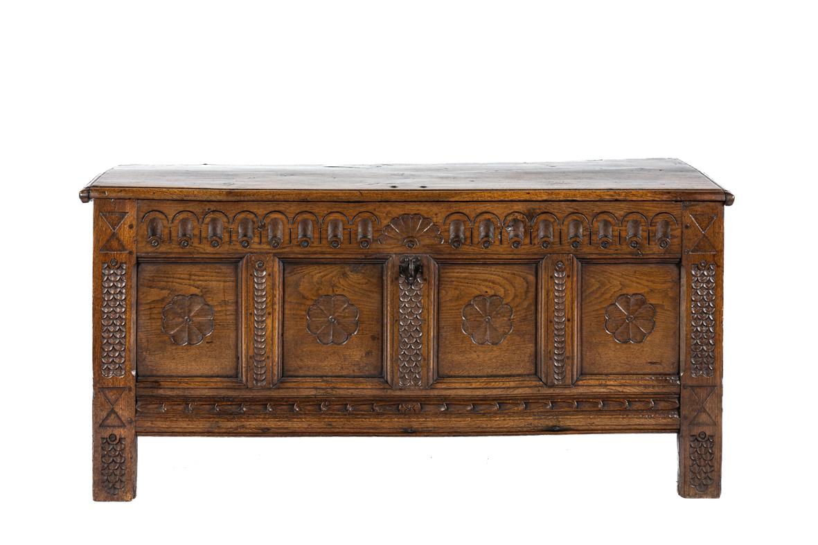 This antique oak chest, dating from the early 17th century, is a remarkable example of early European craftsmanship, combining strength with refined decorative detail. Made entirely of solid oak, it displays a beautiful blonde honey color that has