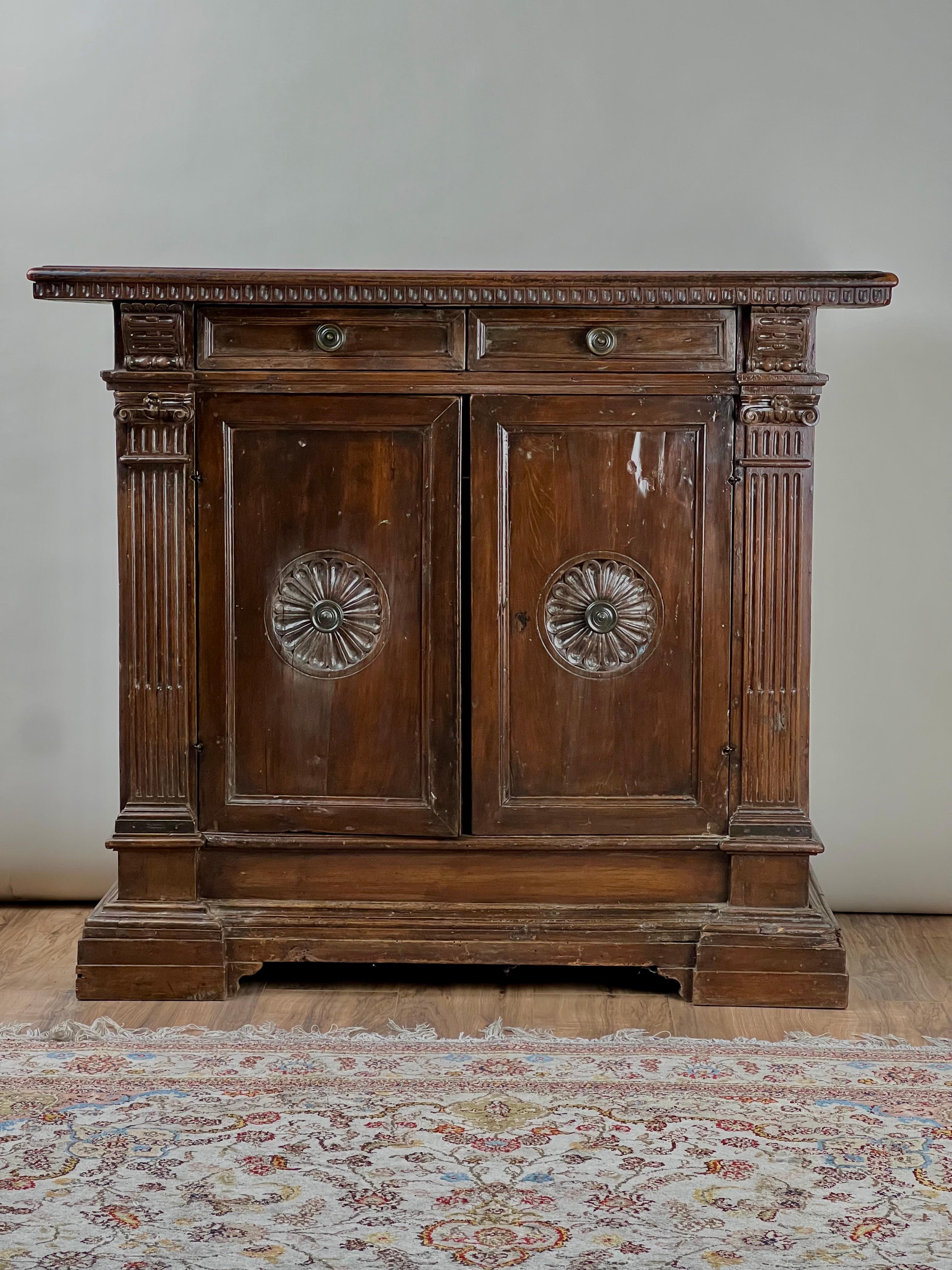 Diese antike italienische Barock-Credenza aus Nussbaumholz spiegelt die Eleganz und Handwerkskunst des späten 17. bis frühen 18. Das wunderschön gealterte Nussbaumholz weist eine reiche Patina auf und hebt die komplizierten kannelierten Pilaster und