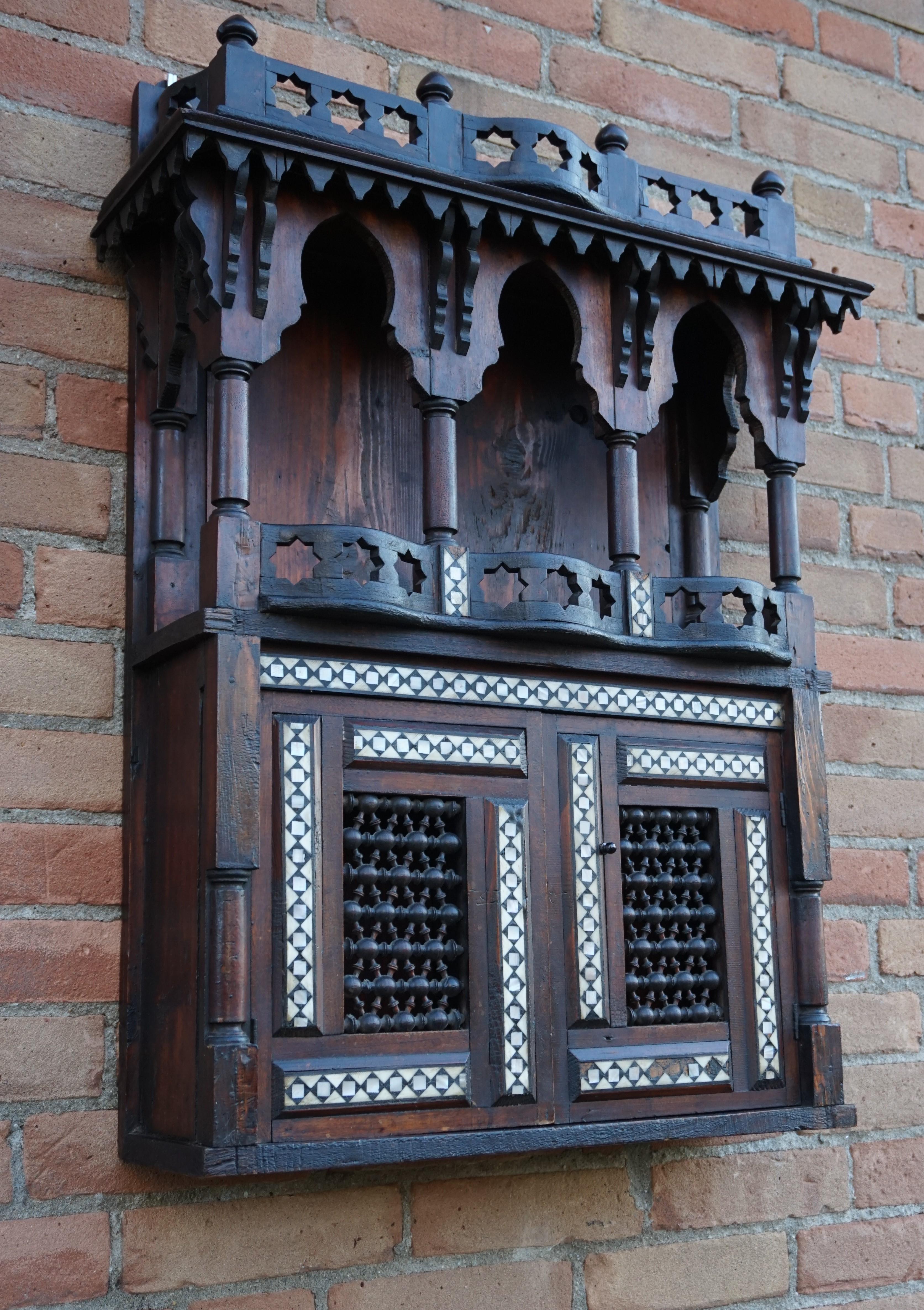Unique and handcrafted late 19th century Islamic style wall cabinet.

This stylish and highly decorative wooden wall cabinet has a beautiful, arabic look and feel. With the use of cow bone and mother of pearl, this unique piece is inlaid with