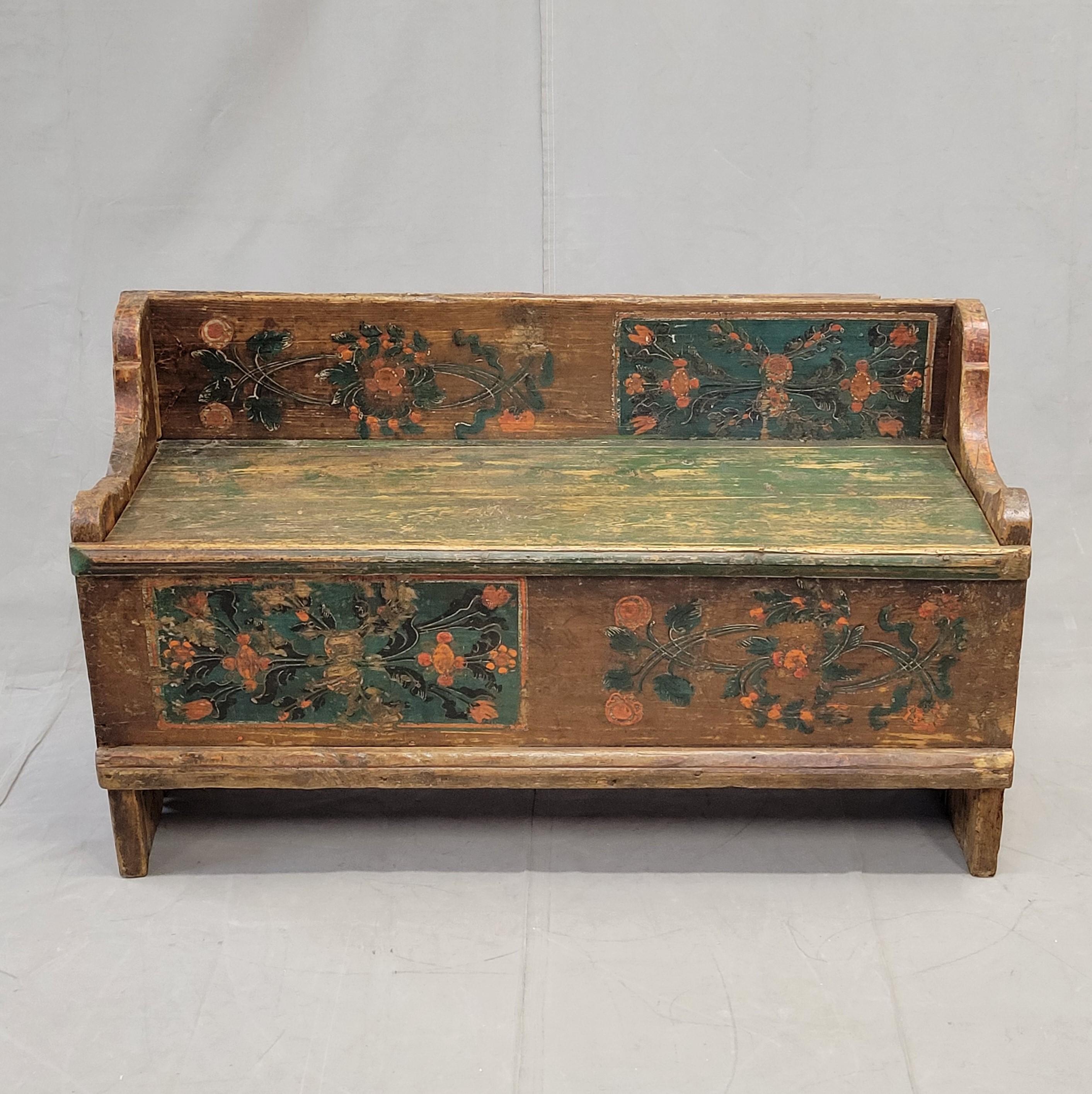 A charming antique late 1800s Romanian rustic pine painted storage bench. Paint is original but abraded due to age and use adding a sweet rustic European to a home. The paint is expertly painted in shades of deep reddish brown, green, blue and
