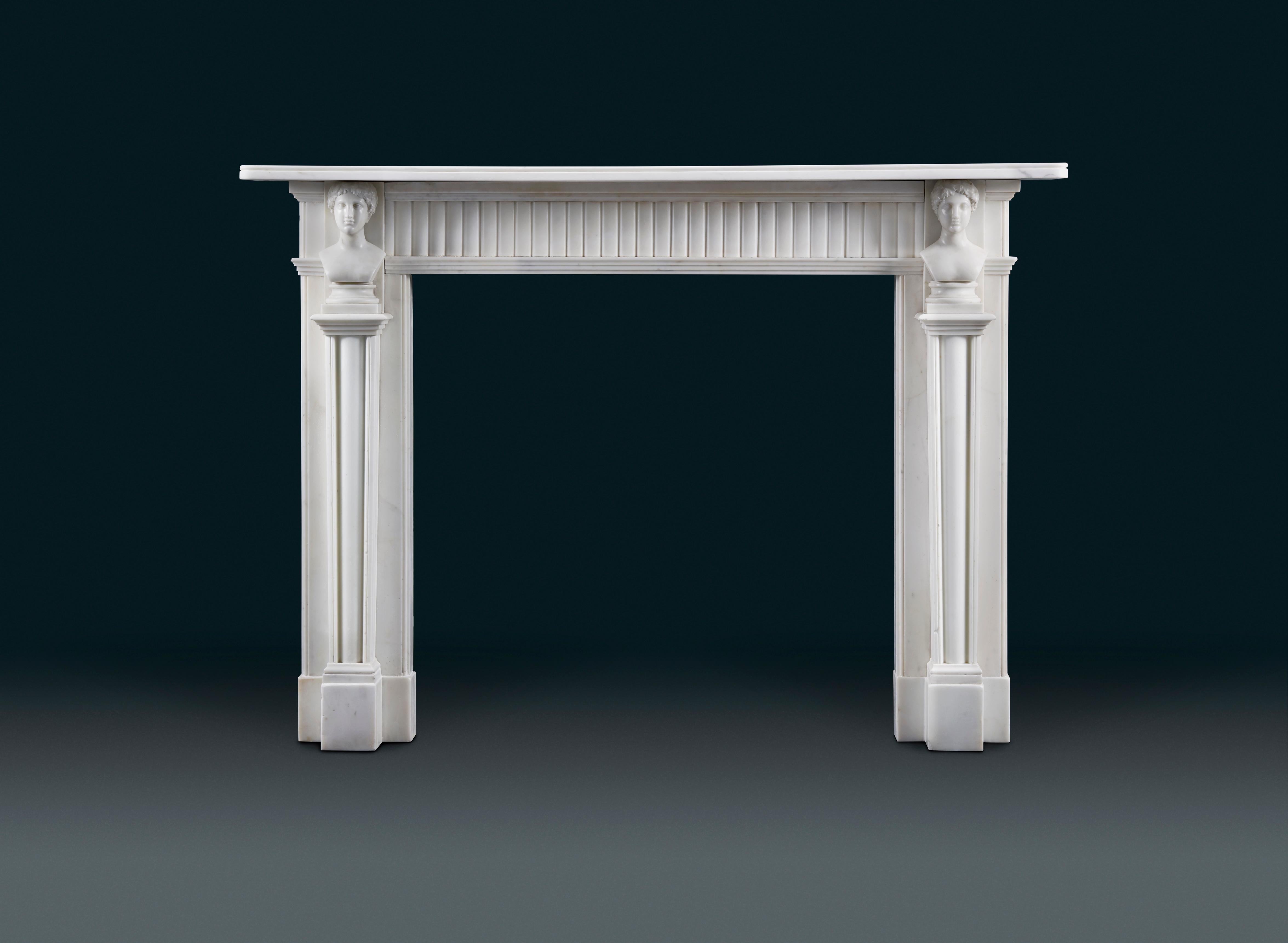 A good antique Irish, late 18th century neoclassical statuary marble fireplace; the frieze with continuous convex rounded mouldings. The jambs faced with elegant Herm shaped, gracefully tapering pedestals decorated with convex shafts surmounted by