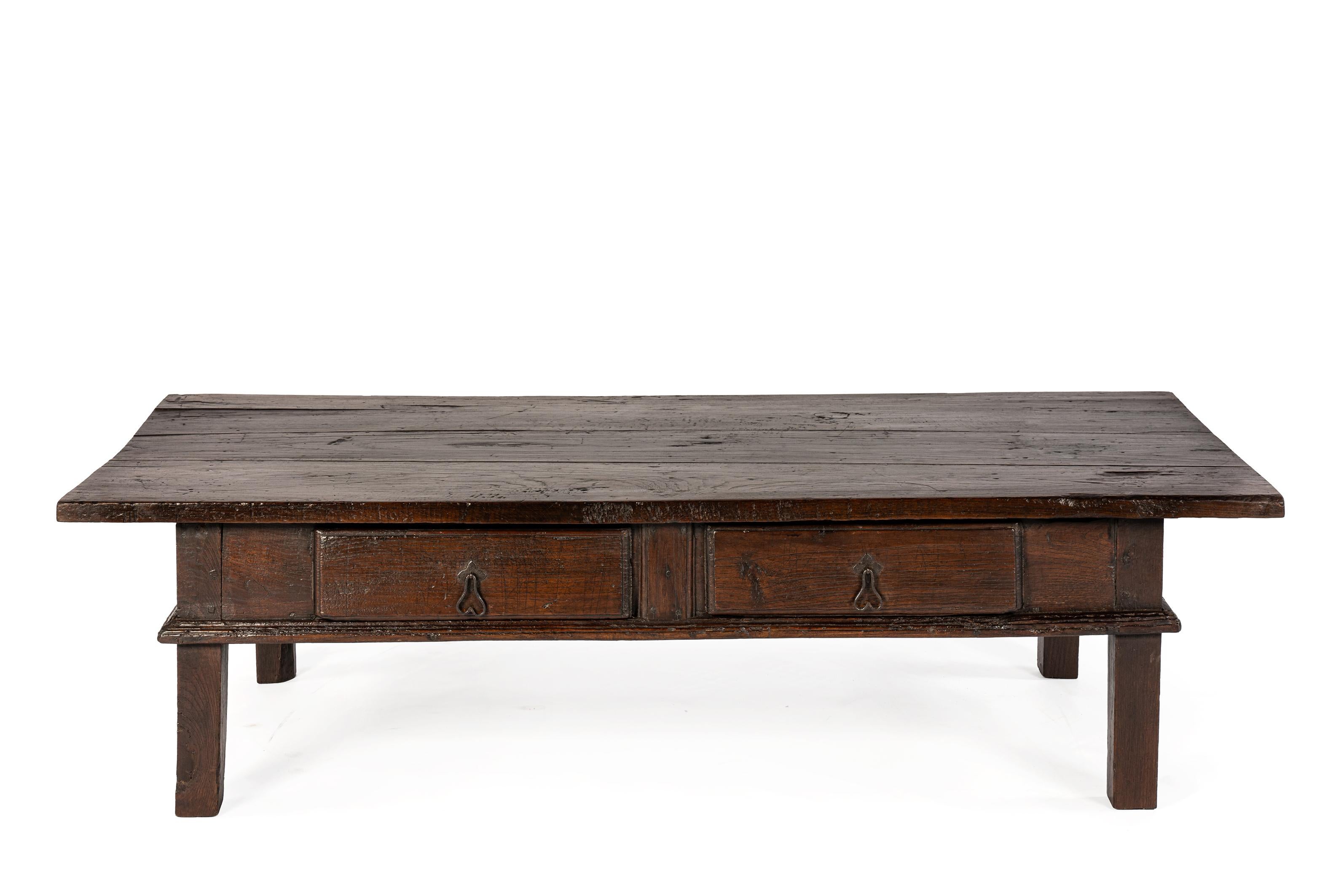 Il s'agit d'une table basse espagnole ancienne en bois de châtaignier massif.
Le plateau généreux est constitué de trois planches larges et mesure environ 3 cm d'épaisseur. La surface présente un éclat naturel profond et une patine riche et bien