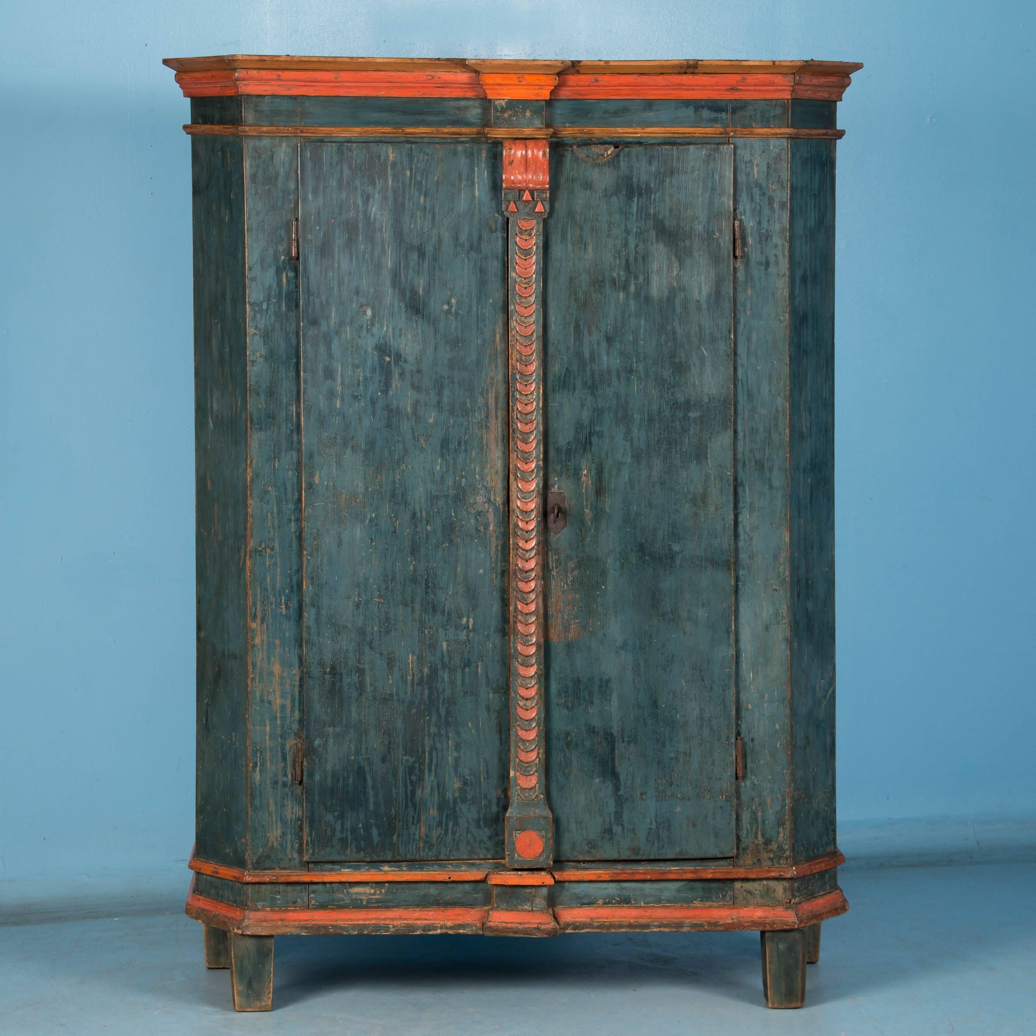 The wonderful lightly distressed blue paint and red trim are all original on this beautiful, late 18th century pine armoire from Sweden. The large interior is open, however shelves and or a hanging rod can easily be installed for a fee if requested.