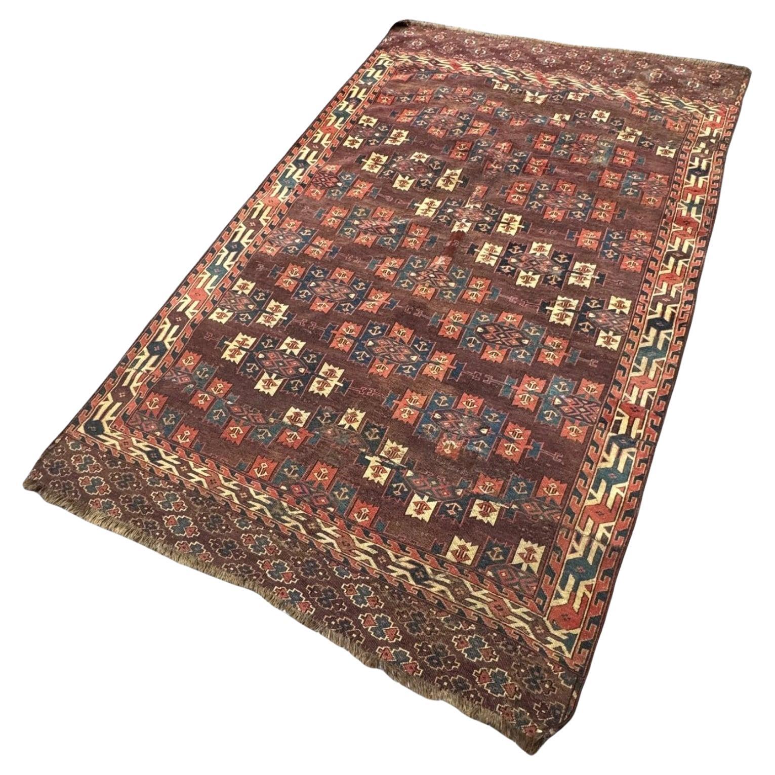 This is an antique Turkmen rug, likely of Yomut or Tekke origin, dating to the late 19th or early 20th century. It measures 2.35m x 1.50m and was originally a longer piece that was cut and carefully mended in the past, a common practice in tribal