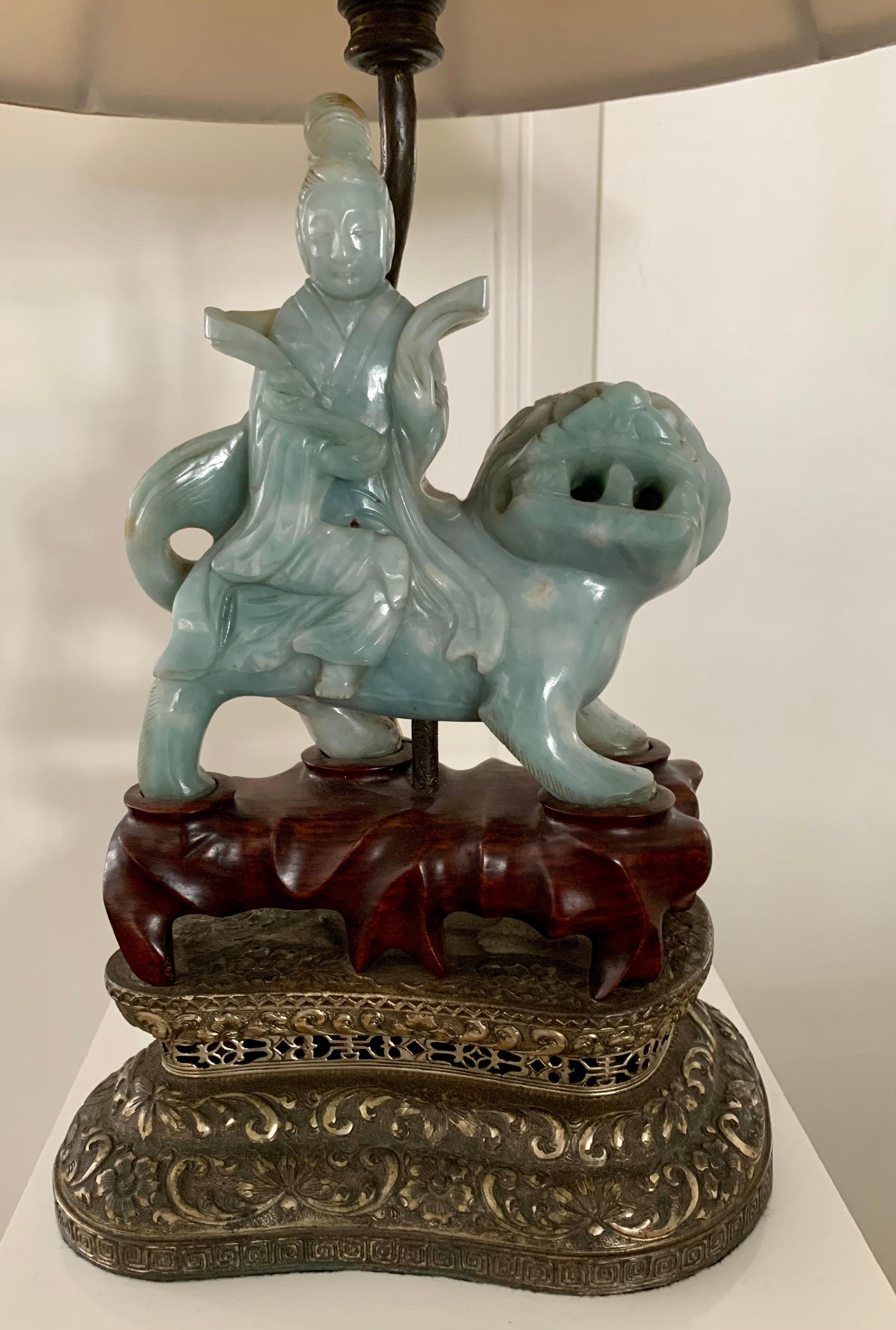 Late 19th century carved jade lamp of a chinese figure sitting on a foo dog. It sits on a carved rosewood and pierced brass base. Comes with shade and carved finial. Use with or without silk shade.
Take one standard bulb.
Measures: 26.5” H to top