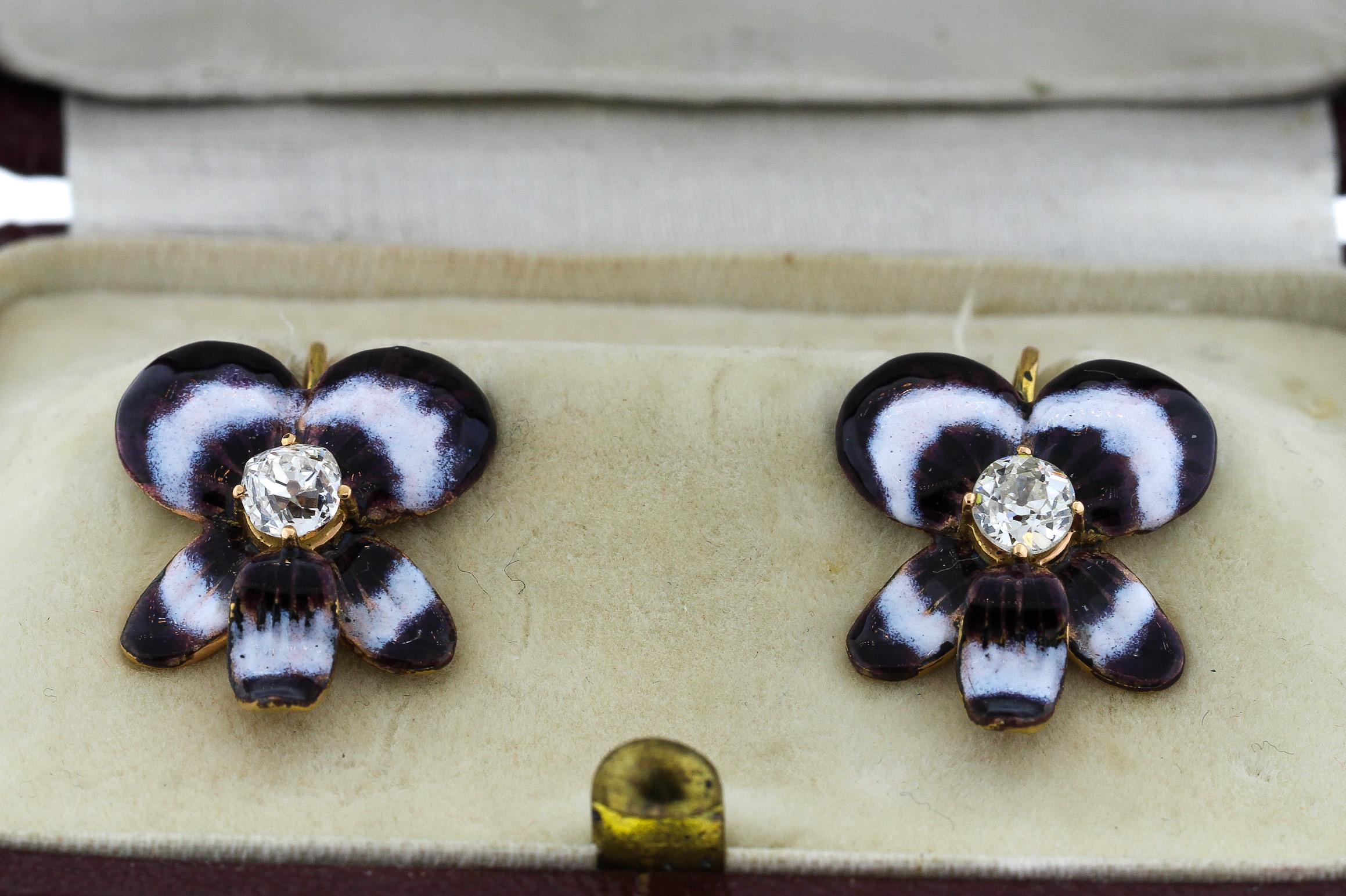 Antique late 19th century purple and white enamel pansy earrings with diamonds, circa 1890. A beautifully colored deep purple pansy with white accents surround an Old European cut diamond. The diamond weighs approximately 0.35 carats and is graded