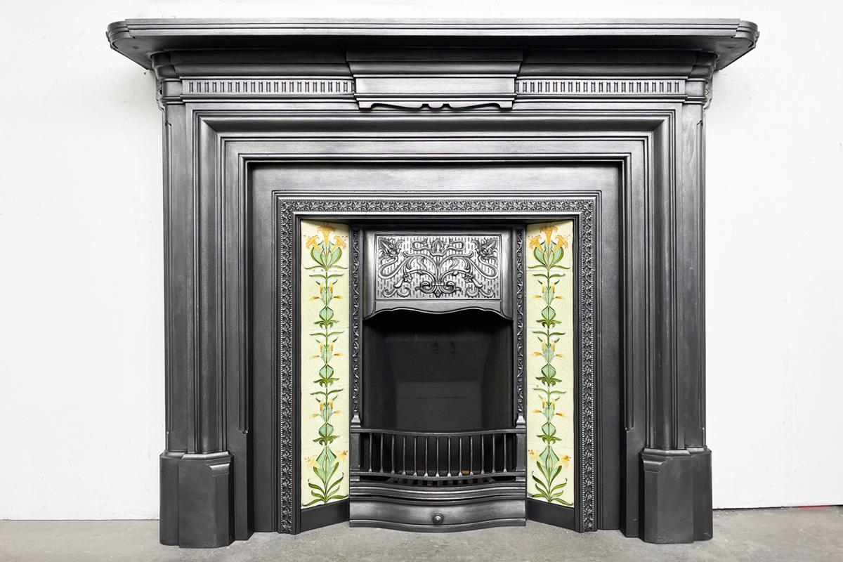 Antique late 19th century cast iron fireplace surround. A collection style moulding frames the fire aperture. Above this is the fluted break-fronted frieze centred with a simple tablet below a generously deep mantle. This surround benefits from