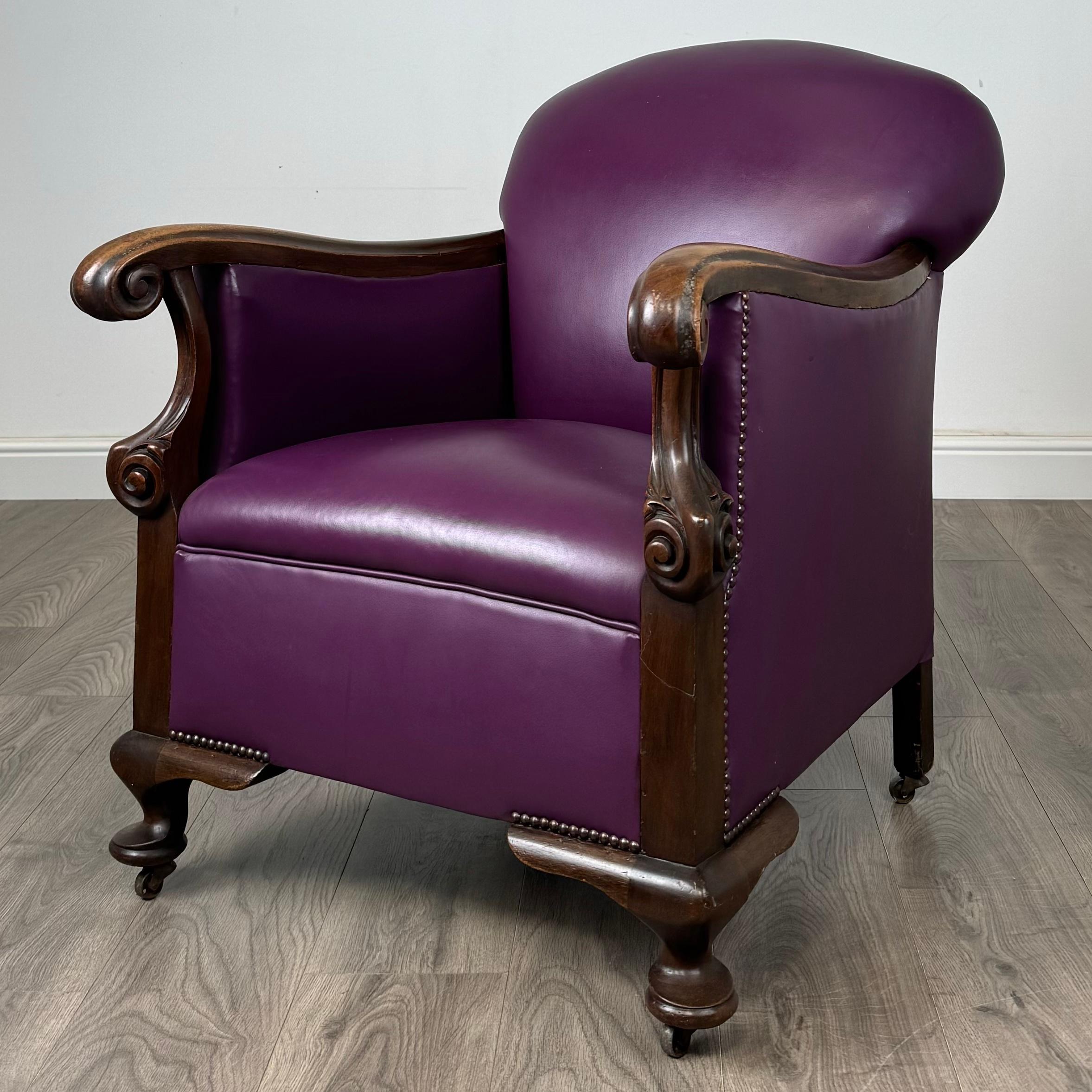 Este sillón club antiguo de finales del siglo XIX irradia elegancia y comodidad, con un diseño de estilo Queen Anne elaborado en caoba. La silla está tapizada en un rico tejido morado que añade un vibrante estallido de color, complementando