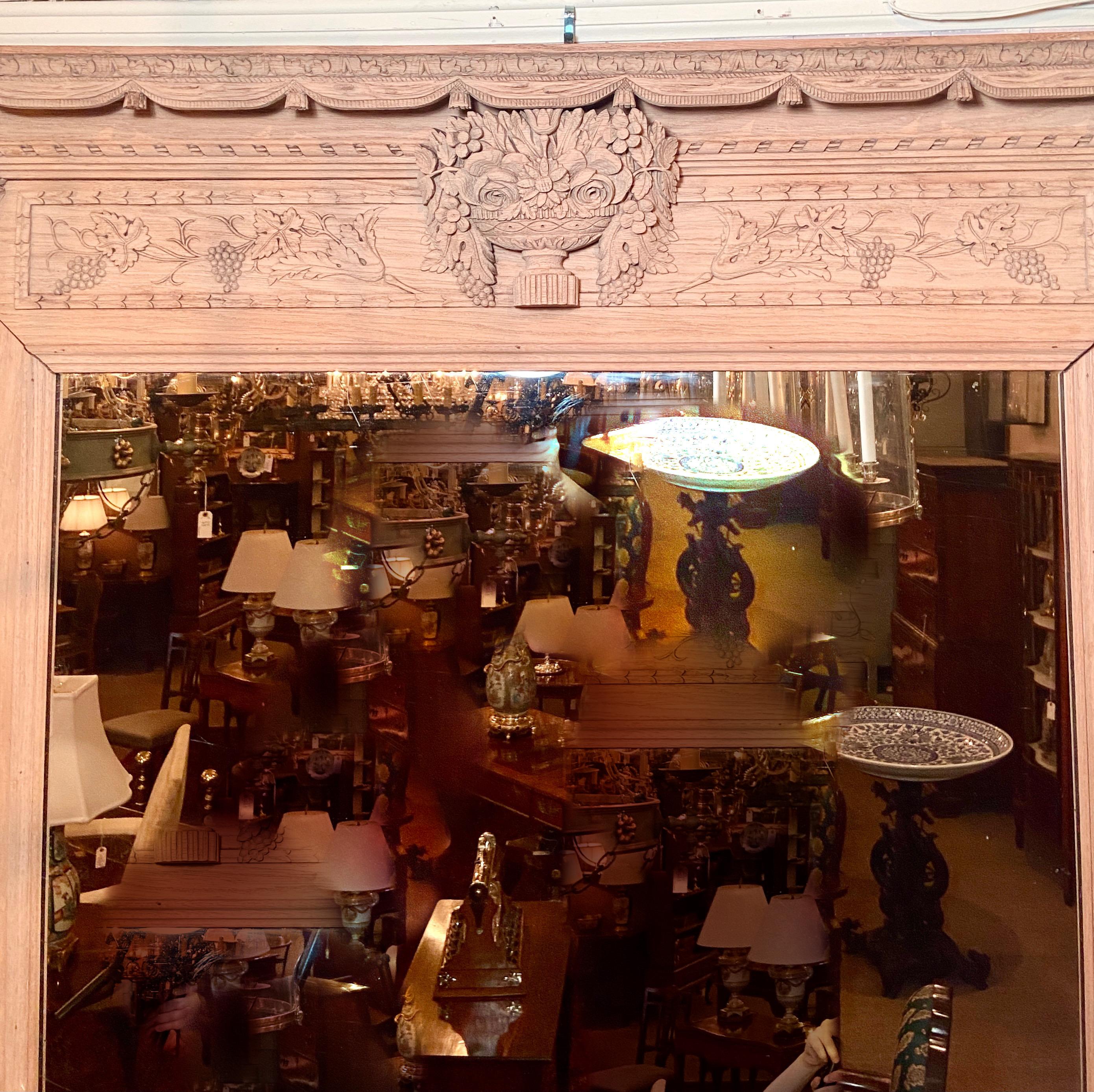 Miroir ancien en bois naturel finement sculpté, datant de la fin du XIXe siècle.