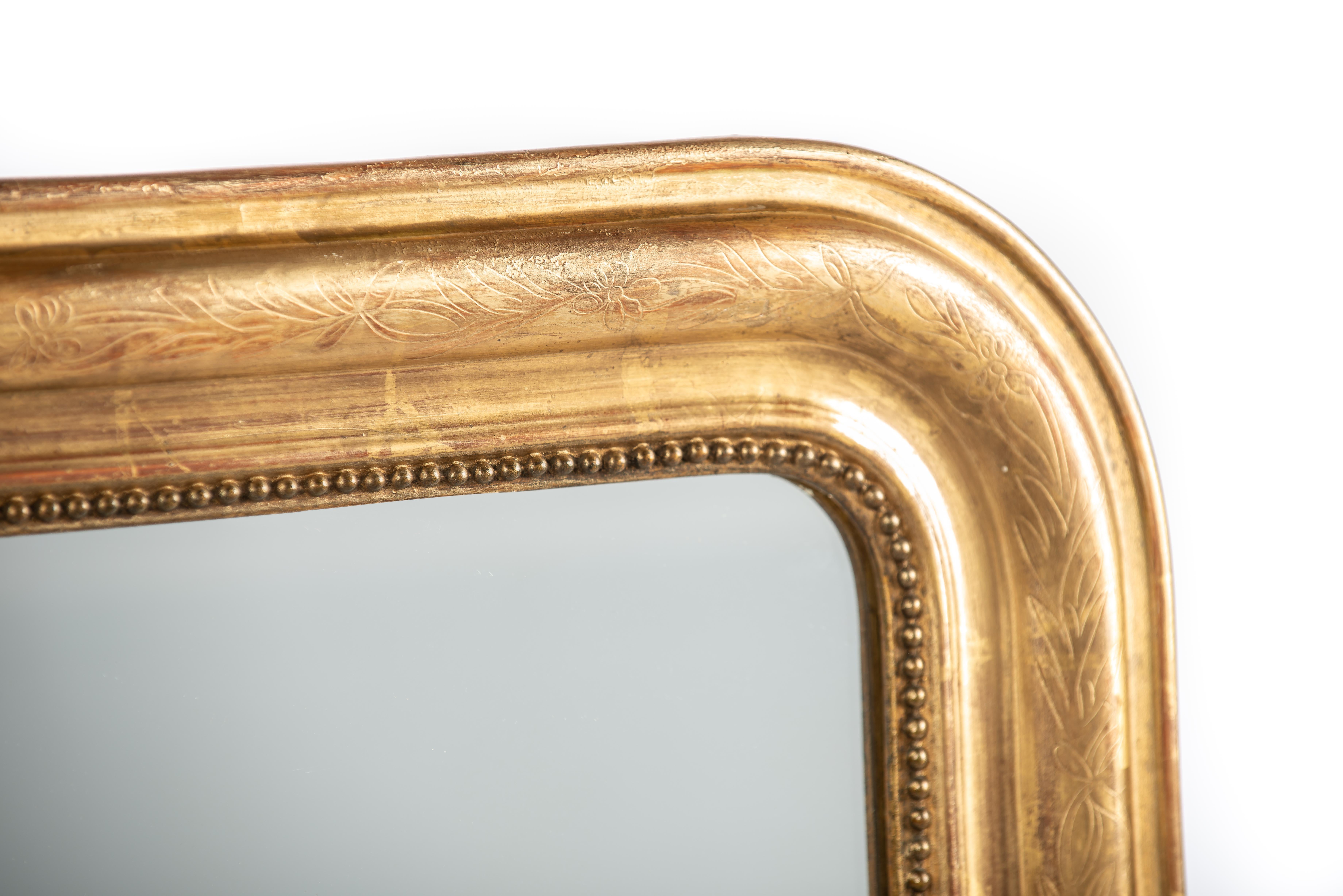 On offer here is a  beautiful antique mirror that was made in France in the late 19th century, circa 1890. It features the upper rounded corners that are typical for the French Louis Philippe style. The mirror has a solid pine frame that was