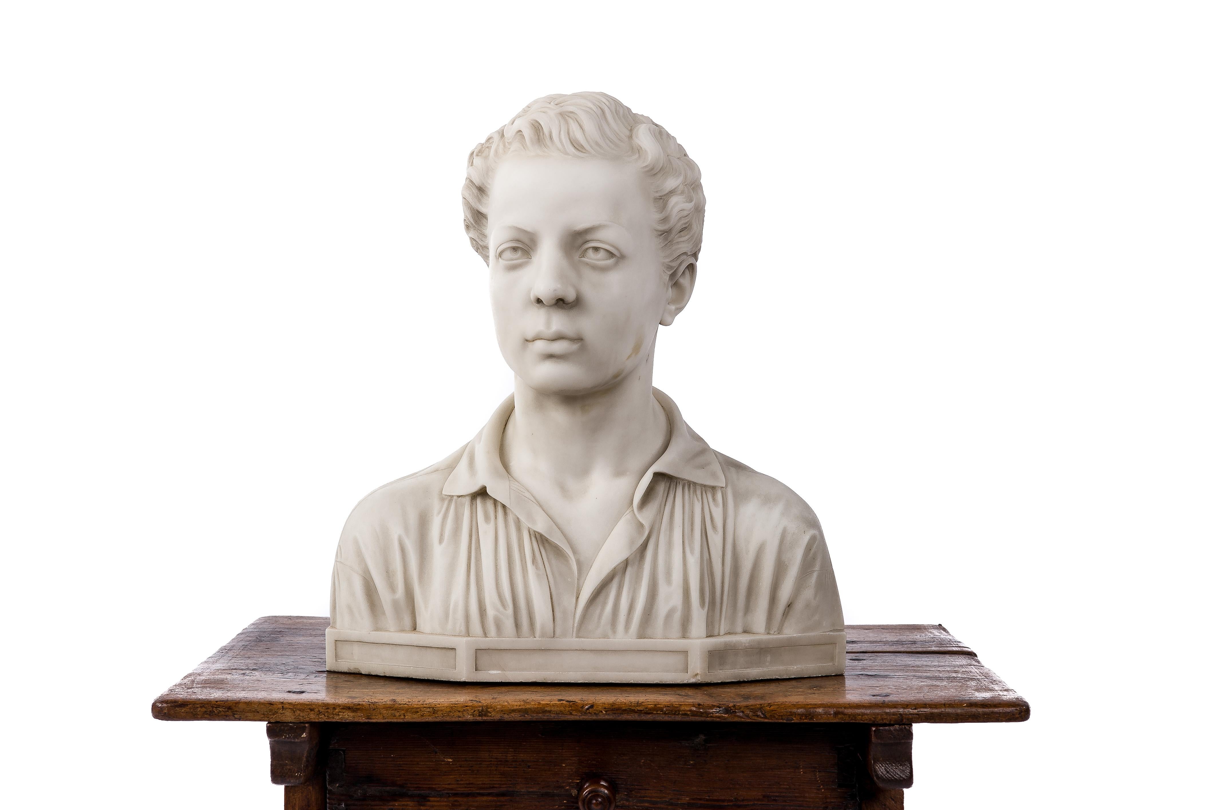 A very handsome white Carrara marble bust of a young boy. The bust is a fine example of the Romantic style with the dreamy look captured in the boy’s eyes. The fabric expression of the boy’s shirt is executed beautifully. The statue has been