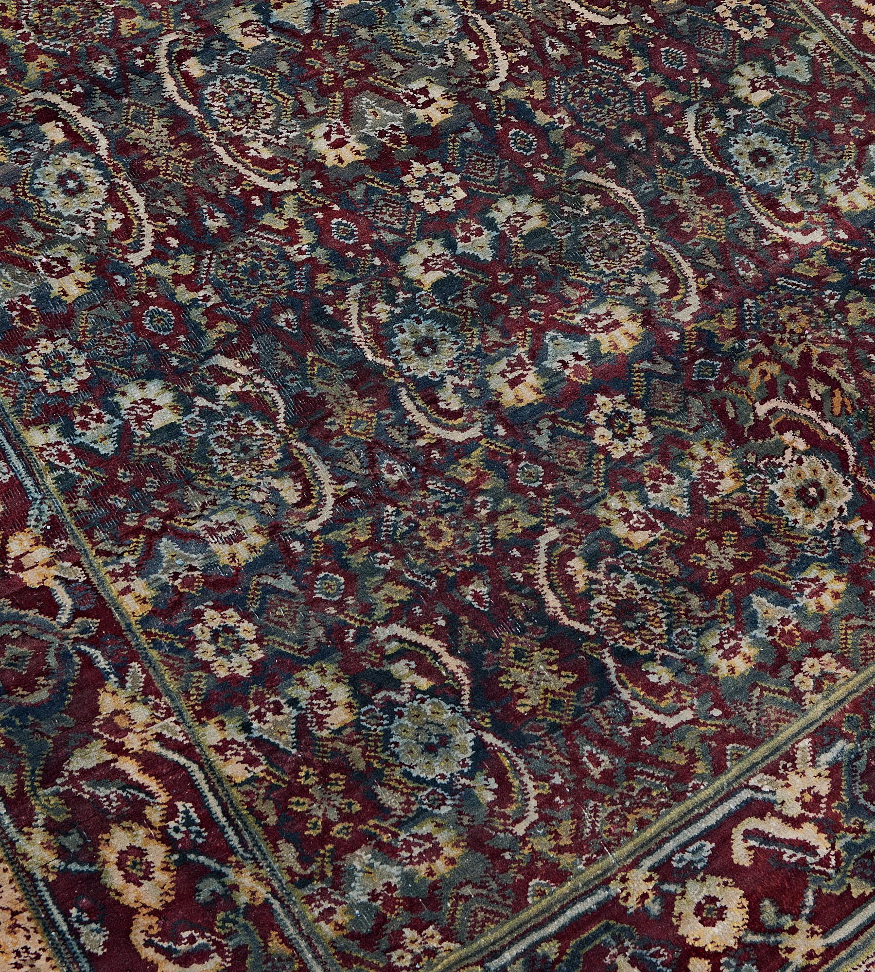 This antique, late 19th century, Agra runner has a shaded sea-blue field with an overall burgundy-red, ivory and sea-green herati-pattern, in a burgundy-red border of ivory and shaded blue meandering flowerhead vine between shaded green and blue