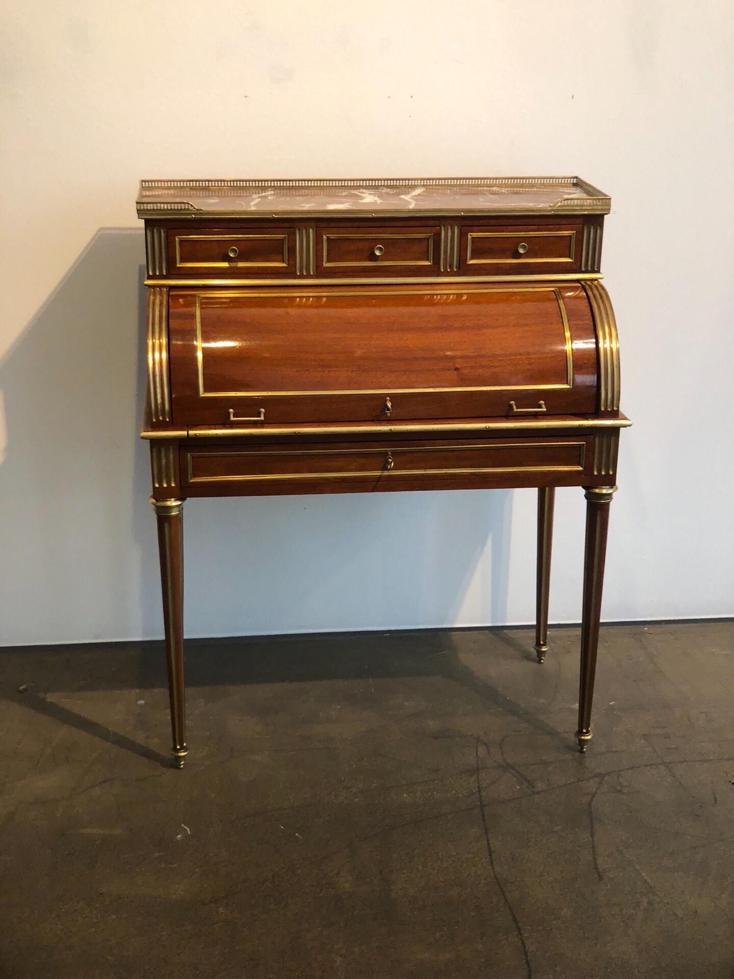 Very elegant antique French Louis XVI style cylinder writing desk from the 19th century. The excellent craftsmanship and high-grade materials, such as polished brass, polished mahogany, leather, and marble, underlines the beauty of this