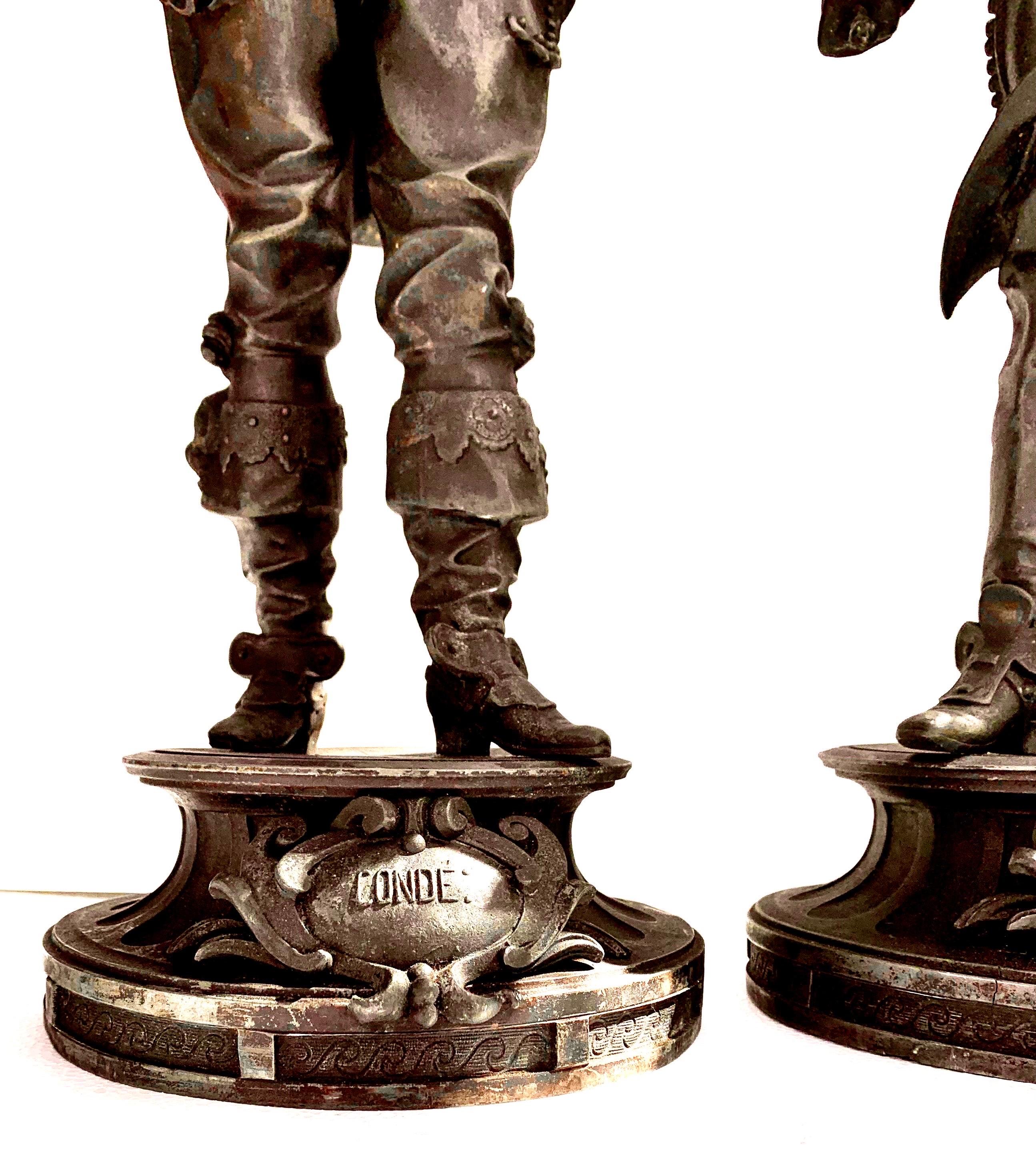 An antique pair of historical figures, Conde' and Vendome. Created in spelter with a patinated, bronze finish, they are a handsome and imposing pair dressed in full French regalia. These are displayed as a pair and history states that they are from