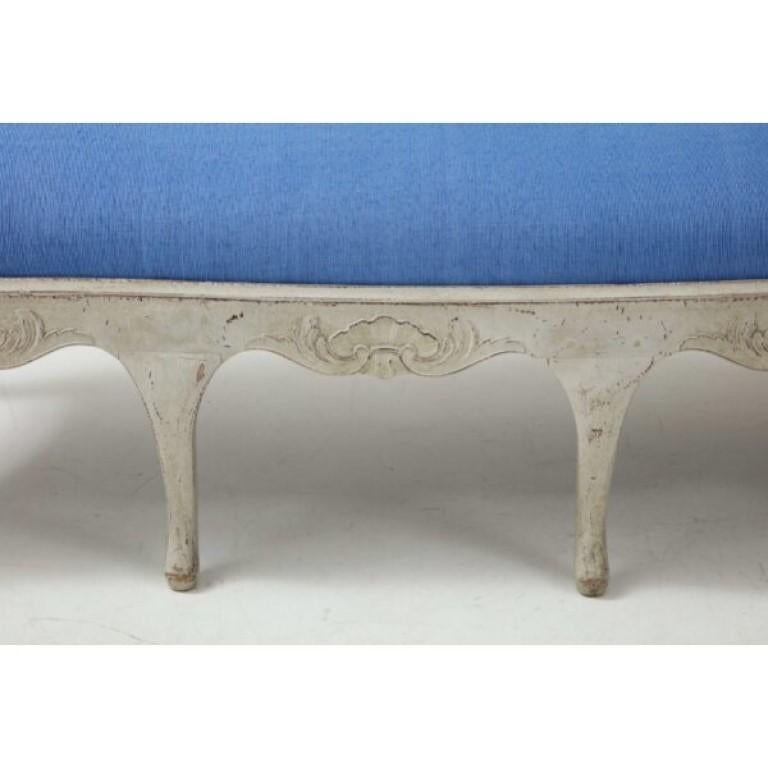 Classic Gustavian style upholstered bench made in Sweden circa 1880. With its first paint, this Rococo bench is painted in a subtle light gray palette. Sinuous carved wood frame is full of playful details. Traditional Swedish vase splat back is