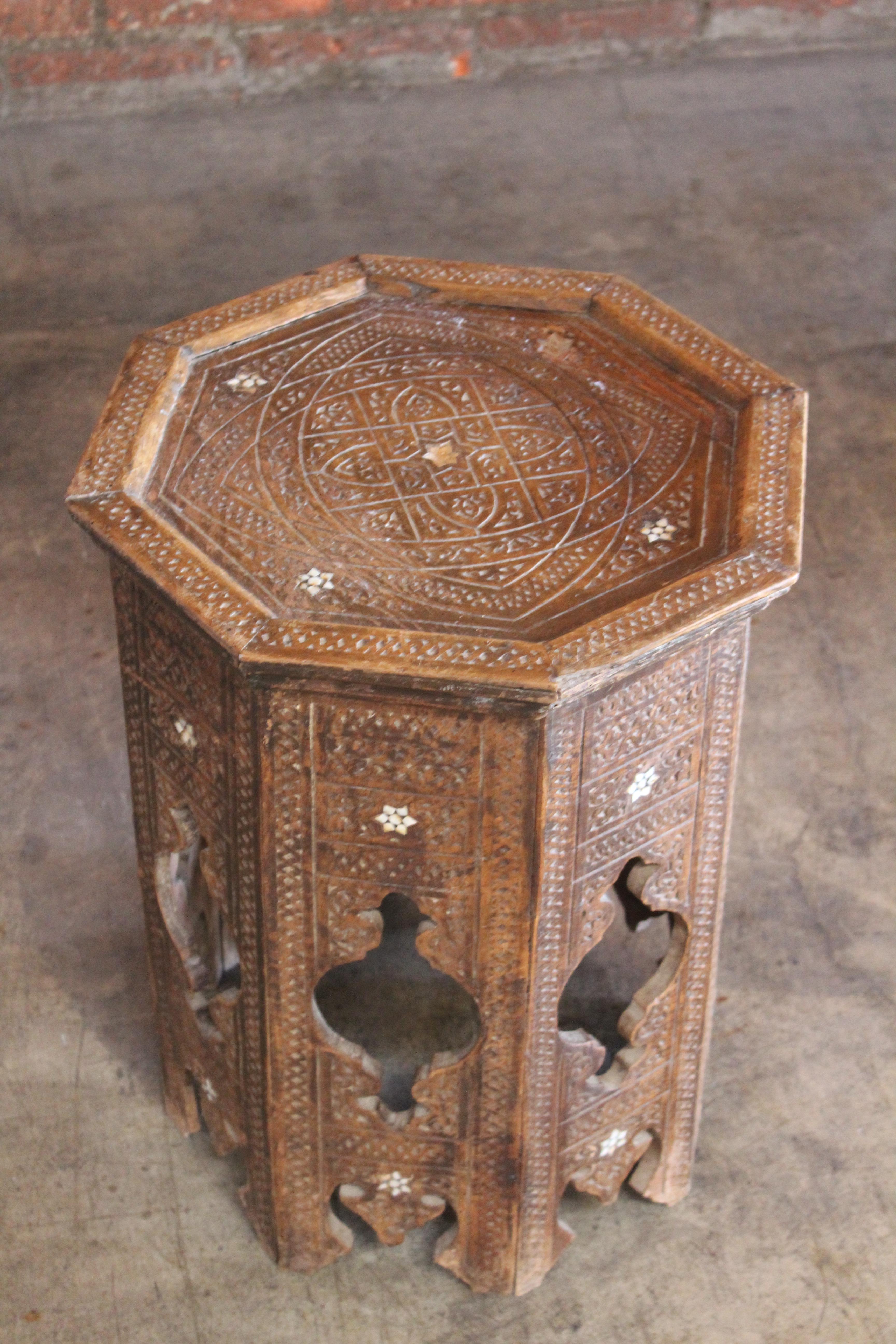 An antique Syrian side table with carved and inlaid details, late 19th century. In overall good condition with wear appropriate with age. Some inlay is missing and fading to the wood finish.