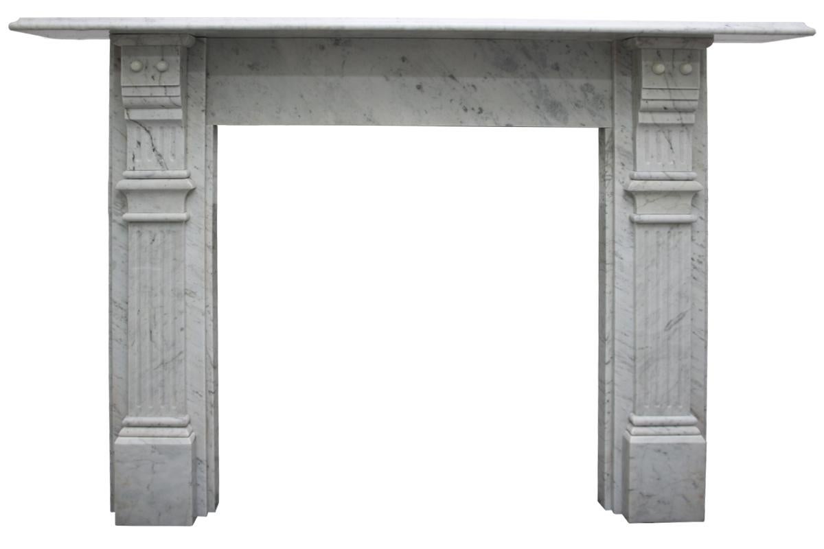 Antique Victorian Carrara marble fireplace surround with fluted jambs terminating in fluted and stepped corbels supporting the shelf, circa 1880. Pictured with an original Victorian cast iron arched insert, sold separately. 

 