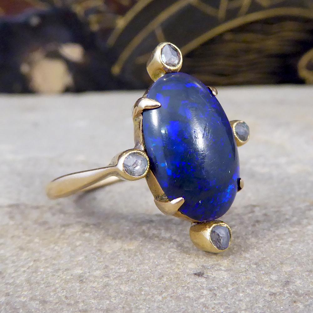 This gorgeous antique ring was hand crafted in the Late Victorian era. It holds a large dark Black Opal stone in the centre with four single Rose Chip Cut Diamonds, one at the top, bottom, left and right of the Black Opal stone. This unusual and