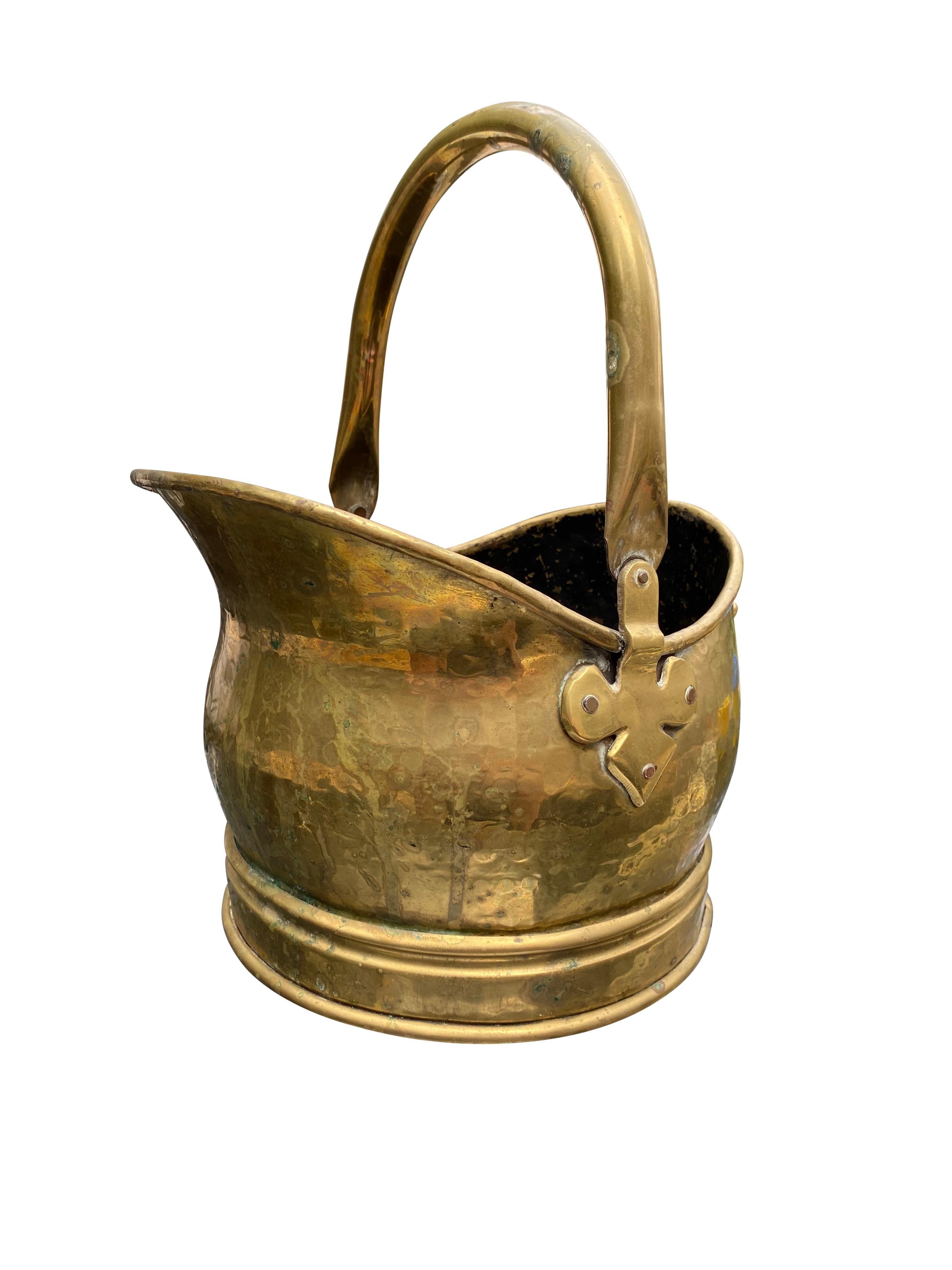 A beautiful antique late Victorian brass coal bucket with fleur-de-lis fittings, circa 1900. The bucket is offered with fantastic patina, and a perfect ageing look. Great for interior design and home decoration. The bucket has a top and rear handle,
