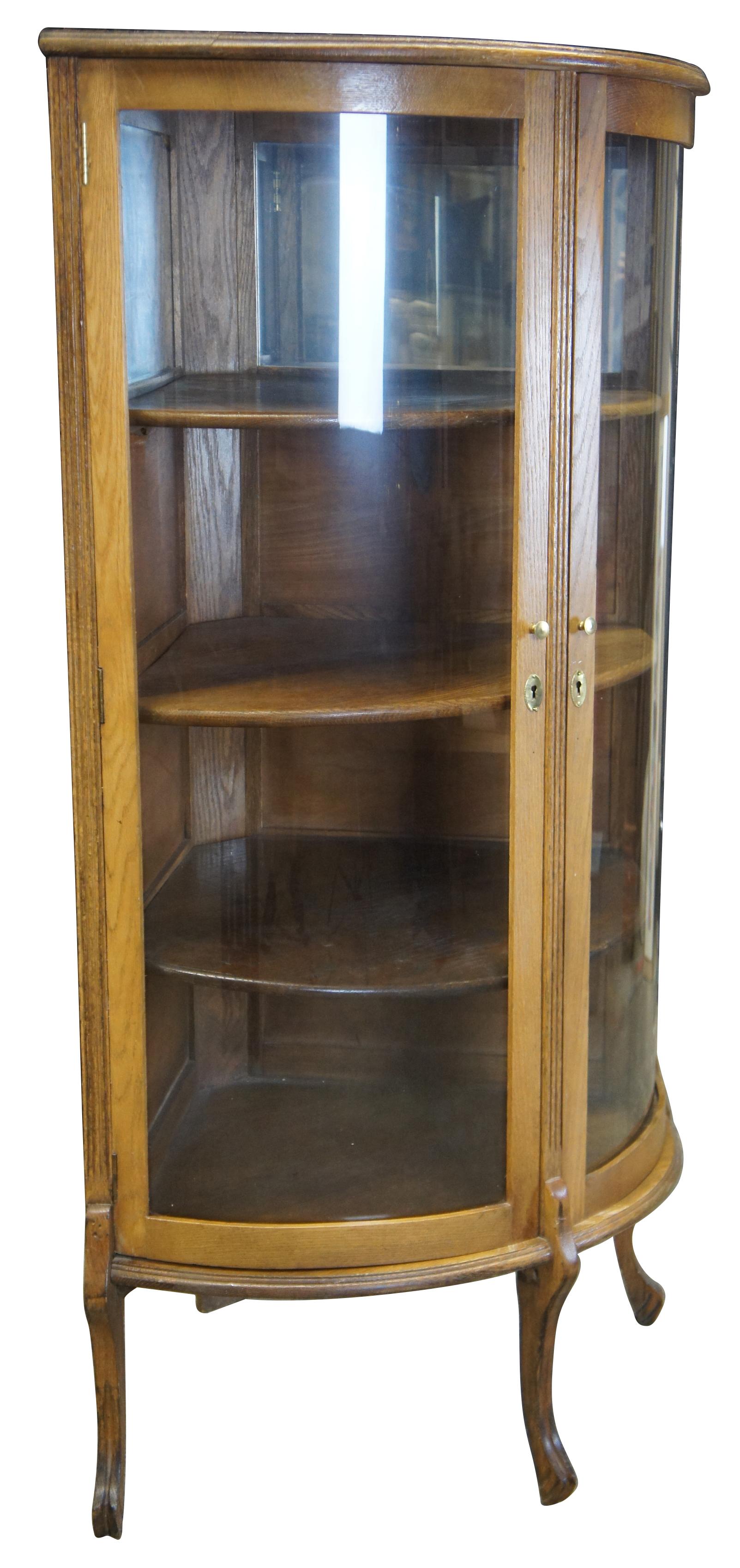 Early 20th century Canadian oak corner curio cabinet. Features three shelves and two mirrors behind doors. Made in Canada.
 